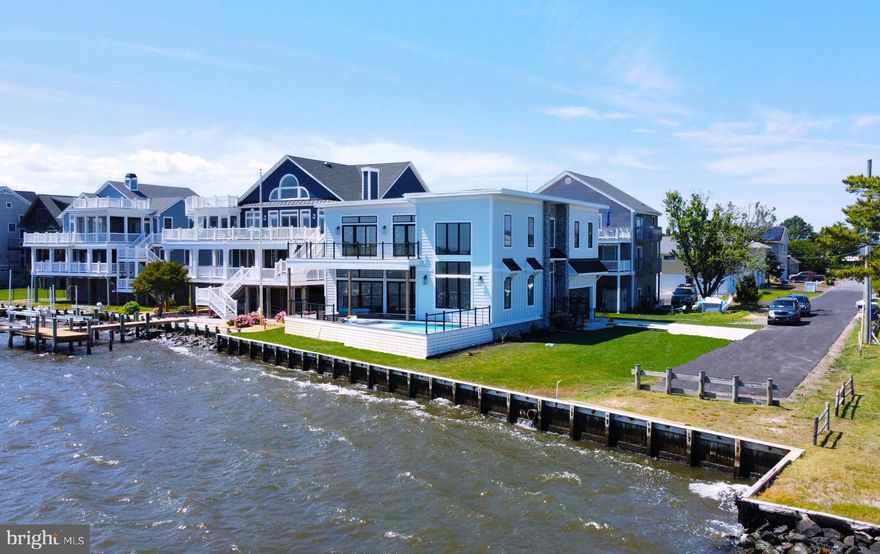 Incredible bayfront home with direct Southern exposure and a private pool overlooking the wide open bay, located within walking distance to the beach! This brand new home is a boater’s dream and has been crafted with the highest level quality and attention to detail, and has been architecturally designed to capture remarkable water views throughout. The stunning great room offers breathtaking bay views through window lined walls, an impressive gourmet kitchen, and an inviting living area with soaring ceilings and a sleek modern fireplace. Two sets of double doors open to a large deck with a pool overlooking the waterfront creating the ideal layout to entertain both indoors and out. Also on the main floor is the first primary bedroom complete with a beautiful bathroom with dual sinks, and a gorgeous tiled shower. The upper level offers an additional entertaining space with a wet bar in the spacious loft that spills onto another waterfront deck. Just off the loft is an additional primary bedroom with incredible water views and spa-like bathroom. The 3rd bedroom also offers an ensuite bathroom and 2 additional spacious bedrooms share a full bathroom. This home will be ready to be enjoyed this summer and for many more to come! Situated on a bulkheaded property with an impressive 95 feet of waterfront, this is the perfect location close to the beach and downtown Bethany, yet tucked away on a non-thru street in a quiet community.