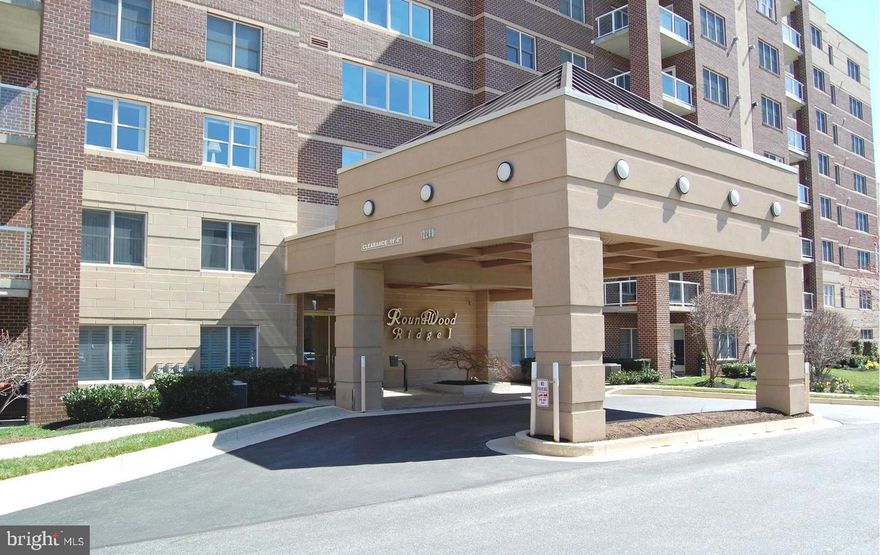 You will fall in love with this 4th  floor unit in the beautiful elevator building of Roundwood Ridge 1! Classic layout with entrance foyer leading to the spacious living room, & separate dining room perfect for hosting dinner parties.  The bright & cheery kitchen offers granite countertops, newer stainless fridge & dishwasher, breakfast bar, plenty of cabinets & counter space, tile flooring, & breakfast/family room complete w/cozy gas fireplace & access to private balcony to relax w/your morning coffee.  Down the hall you will find the laundry room w/full size washer/dryer, two spacious bedrooms, & two full baths. The primary bedroom features large bath w/shower, double sink, walk-in closet plus an additional closet.  Sellers spared no expense with recently installed hardwood flooring throughout most rooms plus elegant tile floors in both baths. There is a storage unit on the same level for all your holiday decorations, & a trash chute.  Convenient location near Roundwood Center featuring Graul's Gourmet Grocery, Koopers North Dining, Walgreens, etc.  PROFESSIONAL PHOTOS BEING TAKEN 2/16.