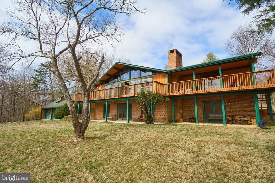 Welcome to Lake Linda.  Fantastic Views of the private late and foothills!  Over 120 pristine and valuable  Acres of both  cleared and wooded land butting up to the Rappahannock River!   The value is in the lake and dam plus the land.  Total privacy and a stream fed lake make the property desirable for growing grapes.  The land is filled with trails and all types of creatures; great for hunting.  Shrouded by 9 wineries and rural farms, Hume is a desirable location close to  Front Royal, route 66 and several other small towns.    This Chalet home was built in 1971  and has views of the Lake from all windows and the large deck.  Front Yard is cleared and easy access to the lake where you can swim, fish or boat.  The property has full privileges & ownership of the Lake which features a Built-In Dock.  There are no additional costs to owning this lake.   Lake Linda is home to many species of wildlife including Fish, Birds & Turtles.   Enjoy nature at its best- deer, fox and wild turkeys can roam freely.  The home features 4 Bedrooms & 3 Full Baths.  Hardwood Flooring.  Wonderful Living Room area and over sized deck  with Magnificent Views to enjoy nature and the lake.  There is a  Country Kitchen , Living room and Family Room with stone fireplace plus 2 large  bedrooms & Full Bathroom on Main Level. Master Suite with full bath on Main Level.  Stairs lead to the Upper Loft Area.   Lower Level comes complete with Rec Room, Bedroom, Full Bath & Unfinished Laundry Area & Storage Room.  There is a Separate 3 car Detached Garage which includes  a darling Studio Apartment with living room, bedroom and full bath.   The lot also includes a Tennis Court and an a shed.    All Buildings including Tennis Court are sold "AS IS".   This is a wonderful opportunity to relax, harvest or hunt.   The home can be torn down, or remodeled  or just rebuild your own dream home  on this fabulous land!   Priced to sell!