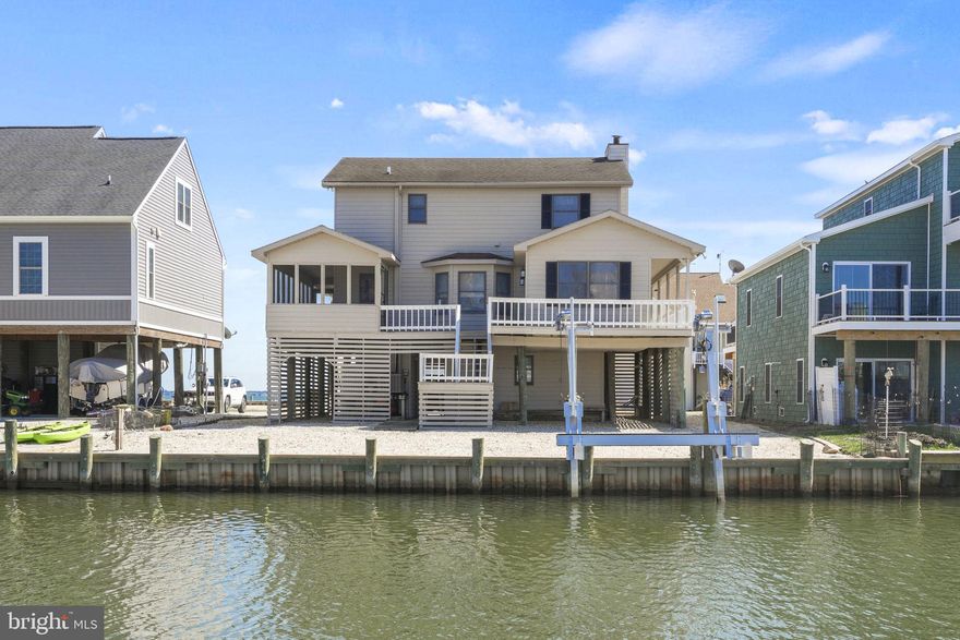 Welcome to this captivating waterfront home, nestled in the desirable Captains Cove community. This exquisite property boasts 3 spacious bedrooms and 2.5 bathrooms, designed for coastal living and unparalleled waterfront views. As you approach, the expansive front deck greets you with breathtaking bay views, setting the stage for the serene lifestyle awaiting you. The rear deck and screened-in porch provide a tranquil vista of the canal, perfect for peaceful mornings and vibrant sunsets. Step inside to the open concept main level, where a spacious living room invites you with its charming fireplace, seamlessly connecting to a cozy sitting area and a sun-drenched sunroom. The kitchen is a chef’s delight, featuring a large breakfast bar and sleek stainless appliances, perfectly complemented by the dining area's gorgeous water views. Upstairs, the primary bedroom offers a private retreat with its own bathroom, providing a serene escape. Additionally, there are two more well-appointed bedrooms, accompanied by a full bath, ensuring ample space for family or guests. Practicality meets luxury with under-home storage rooms, offering convenience and organization. For boating enthusiasts, a new boat lift and bulkhead enhance the property’s appeal, ensuring easy access to aquatic adventures. Experience the harmony of exquisite design, scenic beauty, and modern amenities in this exceptional waterfront home, where everyday living feels like a vacation.