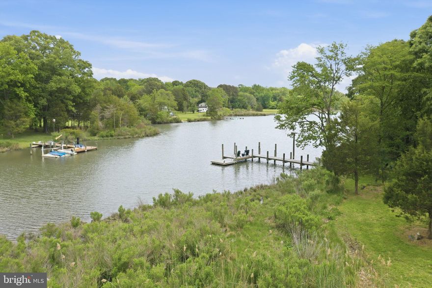 The Ultimate Private Waterfront Retreat on Carrs Creek

Tucked along the shoreline of Carrs Creek in the heart of Southern Anne Arundel County, 5865 Deale Beach Road is the kind of rare waterfront estate that feels worlds away without asking you to give up convenience. Set on nearly 14 private acres, this beautifully expanded and updated farmhouse blends Chesapeake charm, refined finishes, and the freedom of true country living—just minutes from the restaurants, marinas, and small-town energy of Deale, Galesville, and North Beach.

Inside, the home is warm, elegant, and designed for gathering. The spectacular kitchen pairs Viking appliances, white cabinetry, quartz countertops, generous island seating, and a statement light fixture with an easy flow into the family room, where an oversized stone wood-burning fireplace and walls of windows frame peaceful water views. It is the kind of space built for slow Sunday mornings, holiday dinners, and evenings that move effortlessly from the kitchen to the porch to the water’s edge.

The main-level primary suite offers a private retreat of its own, with sliding doors to the deck and hot tub, a large walk-in closet, and an elegant bath featuring a glass-enclosed slate shower and separate jetted tub. A spacious office and additional bedroom complete the main level, while the upper floor offers three more bedrooms, including an en-suite bedroom with its own private screened porch overlooking the creek.

Outside, the property becomes something truly special. Spend summer afternoons by the waterside pool, launch paddleboards and kayaks from your private pier and floating dock, gather around the fire pit after sunset, or practice your short game from the tee box. Screened porches, stone patios, open lawn, and wide water views create a lifestyle that feels equal parts luxury retreat and Chesapeake homestead.

For those craving space, privacy, and purpose, the grounds deliver. A fenced garden area with chicken coop, gardening shed, vegetable garden, and room to roam brings fresh eggs, homegrown vegetables, and a slower rhythm to everyday life. A large detached garage with a bathroom and second level is ideal for a car enthusiast, workshop, studio, equipment storage, or hobby space. A commercial whole-house generator adds peace of mind, keeping the property ready in every season.

Private, polished, and incredibly versatile, 5865 Deale Beach Road is more than a waterfront home—it is a full-scale lifestyle property. Whether imagined as a year-round residence, a weekend escape from the DC region, or a legacy retreat close to Annapolis, Joint Base Andrews, Northern Virginia, and the Chesapeake Bay, this is Southern Maryland waterfront living at its most complete.