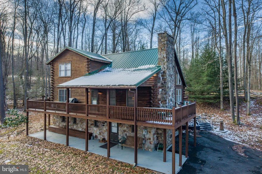 Don't miss this beautiful log home in the heart of Deep Creek Lake located on Lake Shore Drive. Open floor plan, tall ceilings, and a large stone fireplace in the living room.  There are so many features to give you those cozy lake cabin vibes you're looking for.  With 3 bedrooms and 2 1/2 baths, this home offers a  main level primary bedroom with walk-in closet, eat in kitchen, and a large deck perfect for entertaining.  An attached garage sits below the home, and an additional 2 car garage is located on the property. Sitting on just over an acre with filtered lake views of the beautiful Deep Creek Lake.