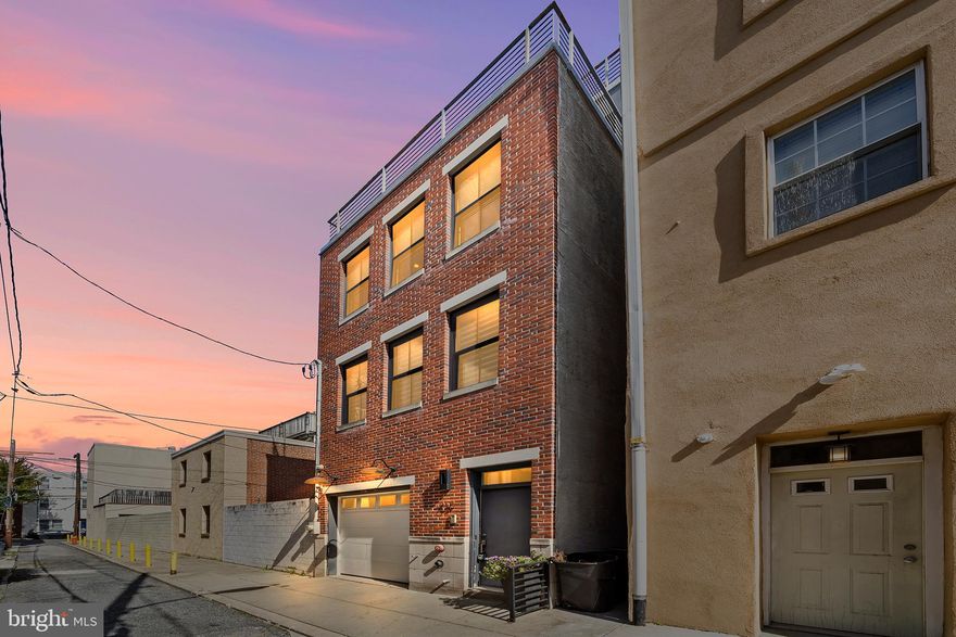 Come see this stunning 4 bedroom, 3.5 bath Townhouse Style Single family with garage parking plus the most amazing unobstructed views of Center City, from the primary suite balcony and rooftop deck, that Bella Vista has to offer. This home’s classic brick façade transitions into a contemporary interior with more traditional accents and high-end finishes. Enter through either the one-car garage or the front door to be welcomed into a foyer that towers to the second floor with Santos mahogany hardwood floors that continue throughout the entire home. The first floor offers a flex space with a closet that could be either a bedroom or a home office and has a half bath. On the second floor you'll find a custom built kitchen with state of the art GE Monogram appliances, white Quartz countertops, an oversized center island, and a beverage bar. The open floor plan on this level also includes a full dining room and a living room. The third floor offers two ample sized bedrooms, one with custom built-in cabinetry, a full hall bath and the ultra-convenient laundry room with a sink. Coming to the fourth floor, you'll find the primary bedroom suite with a walk-in closet, second closet and a luxurious ensuite with a stall glass enclosed tiled shower. The balcony off the primary bedroom is positioned perfectly to enjoy the best view of the city. Access the amazing rooftop deck with built-in lighting, sound system access and unobstructed 360 degree views of the city including the Ben Franklin Bridge to the east and the Center City skyline to the northwest is from this level. A full finished basement with 11 foot ceilings, custom built-in cabinetry, a porcelain tile floor, a beverage center with a refrigerator and a full bath creates even more functional living space. This home boasts three zone central air and heat, a smart home system allowing control over the AC from your smartphone, a built-in speaker system throughout the entire house and a three zone intercom system with a camera. This home is also in a prime location being within blocks to the Italian market, a dog park, Whole Foods, and a plethora of restaurants and bars. Two years remaining on the tax abatement!!