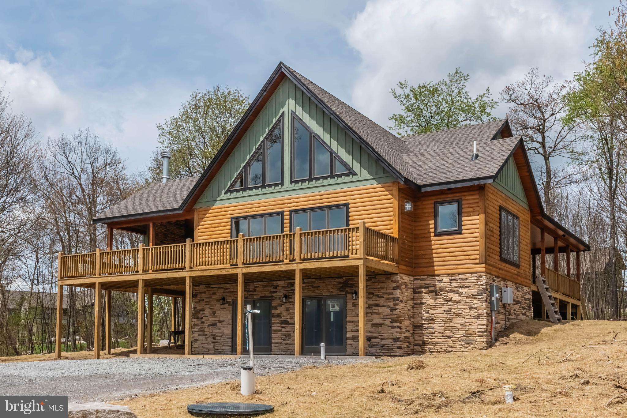 New construction Mountaineer log home in the mountaintop community of North Camp. This home offer three levels of living space and an abundance of windows, allowing plenty of natural light along with great mountain views. The luxury vinyl flooring, cathedral ceilings, and stone fireplace are just a few of the nice features this home has to offer. With 5 bedrooms and 4.5 baths, you have plenty of space to make this a full-time or secondary residence. The outdoor amenities are perfect for entertaining – a covered porch with a woodburning fireplace, a nice wrap around deck that is partially covered, and a path that easily gets you to the slopes and chairlift #7. You are also very close to the whitewater course, Wisp Ski Resort, restaurants, and Deep Creek Lake.