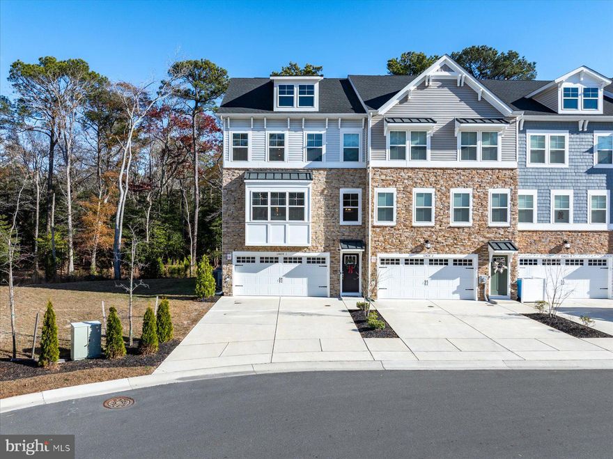 One of the best lots you will find in Sea Oaks Village, a new luxury townhome community in the heart of West Ocean City.  This rare 4-bedroom, end-unit offers great natural light and private wooded views.  Built in 2022, never rented and occasionally occupied as a second home, you would think this beach house is brand new.  Over 3,000 sqft of well-designed living space with beautiful upgrades and high-end finishes throughout.   This dream kitchen is perfect for cooking and entertaining.  Incredible quartz countertop island, tiled backsplash and soft close cabinets.  The Frigidaire Gallery appliances include double wall oven, induction cooktop and French door refrigerator.  Durable LVP floors flow throughout the main floor.  Large back deck is great for grilling and dining outdoors.  The third-floor features 3 bedrooms and two full bathrooms.  Here you will find the south facing owner’s suite with walk-in closet and attached bath with double sink vanity and frameless tile shower.  The first floor also has a spacious en-suite bedroom and bathroom.  On the 4th floor you have a great loft area with powder room and private rooftop deck.  Sea Oaks offers a resort-style neighborhood with a community pool, pier and pond, playground, basketball court and pickleball courts.  One mile from water access and amazing restaurants in the West OC Harbor.  Only a few miles from the beach and boardwalk in Ocean City.  And just down the road from Assateague Island and downtown Berlin.