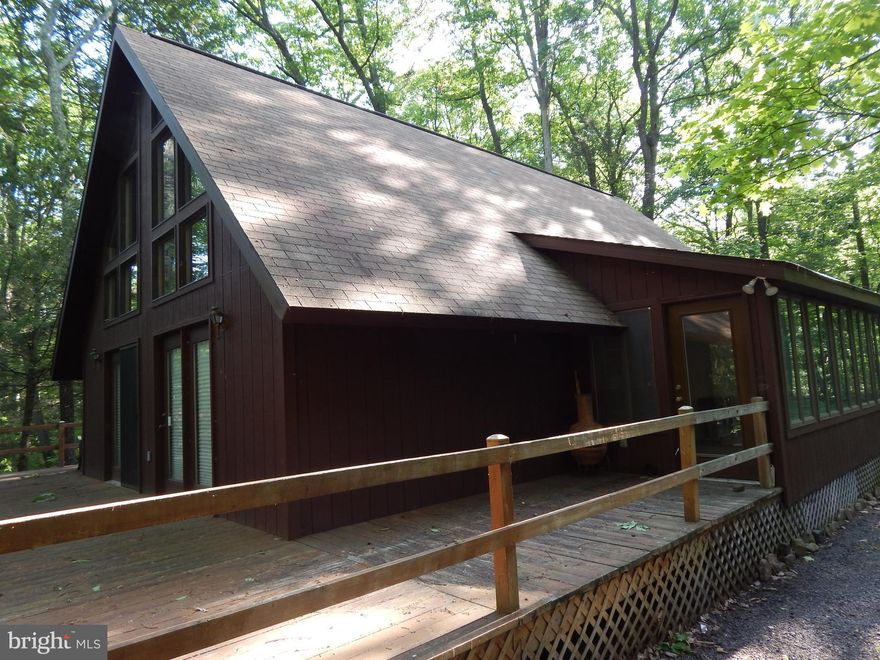3BR, 2BA Chalet overlooking Meadow Branch, located East of Berkeley Springs. Whether relaxing on the deck or inside chalet, the sounds of the cascading stream is a great stress reliever.  Great room area w/ dining, features a wall of windows to enjoy the tranquil scenery, w/ a wood stove during cooler temps. 2 BR, 1BA & Sunroom on main level + BR & BA on upper level. Steps to the stream & privacy