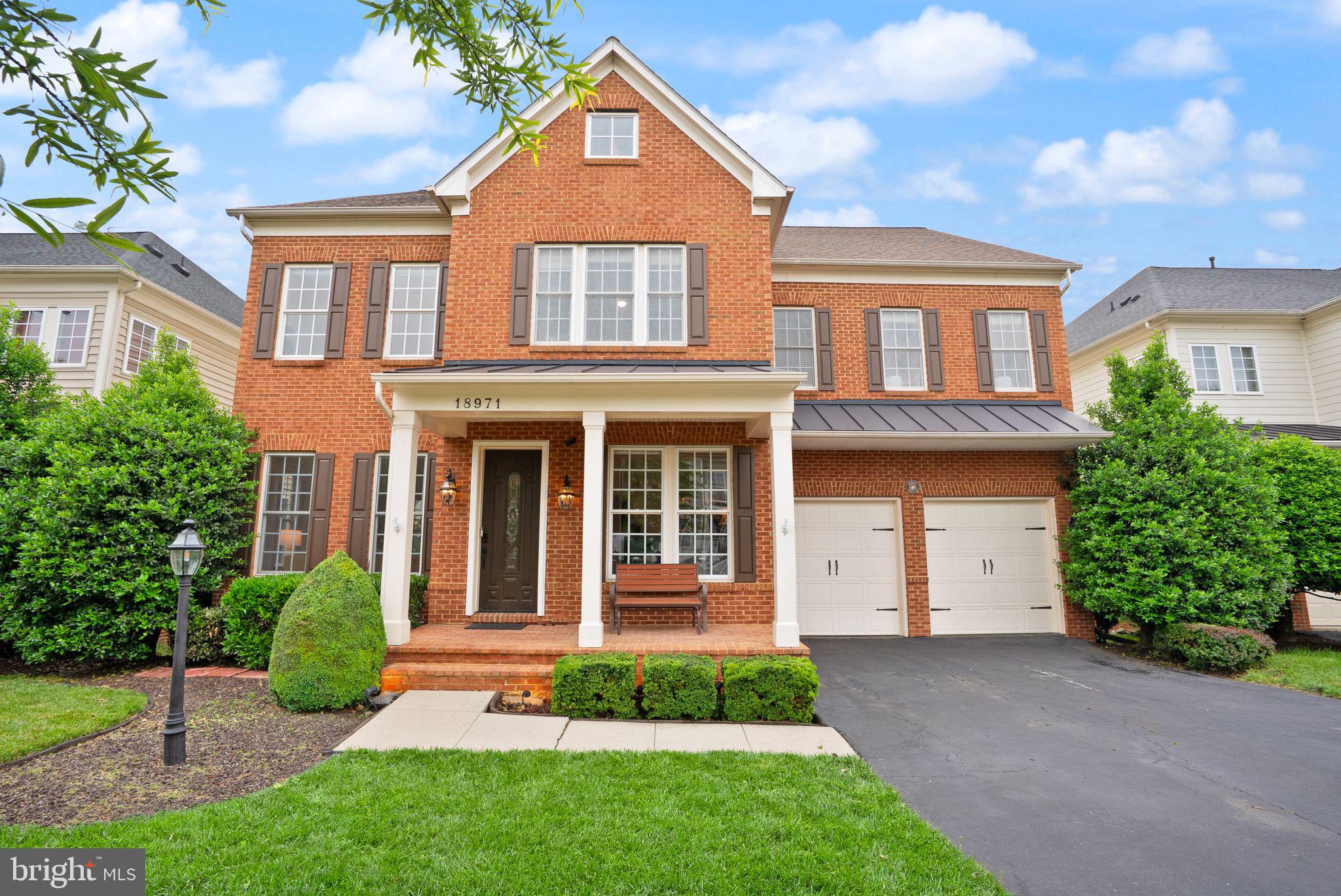 OPEN HOUSES CATERED ON SATURDAY 5/24 FROM 3-5 AND OPEN HOUSE SUNDAY 5/25 3-5 PM. Welcome to 18971 – a beautifully finished brick-front home offering over 5,000 square feet of stylish and functional living in Lansdowne on the Potomac.
Inside, you’re greeted by warm hardwood floors, crisp trim work, and elegant architectural details. The open main level flows effortlessly from a spacious living area with a stone fireplace into a large, well-equipped kitchen featuring granite countertops, double wall ovens, a gas cooktop island, and rich wood cabinetry—perfect for everyday living and entertaining alike.
Upstairs, the generous layout includes four oversized bedrooms, all with walk-in closets. The luxurious primary suite offers a private sitting area, three walk-in closets, and a stunning en-suite bath with dual copper vessel sinks, a granite-topped vanity, and a glass-enclosed shower.
The fully finished walk-out lower level is designed for entertaining, with a dramatic bar accented by LED lighting, a custom theater space with built-in surround sound, and sleek modern finishes throughout. Whether you’re hosting game night or movie night, this space has it all.
Step outside to a spacious Trex deck with integrated lighting, perfect for enjoying views of the open common area beyond the backyard. Even the garage is thoughtfully upgraded with finished concrete floors, ceiling fans, storage cabinetry, and wood paneling.
Lansdowne on the Potomac offers resort-style amenities and convenience to nearby shops, dining, golf, and major commuter routes. Welcome home.