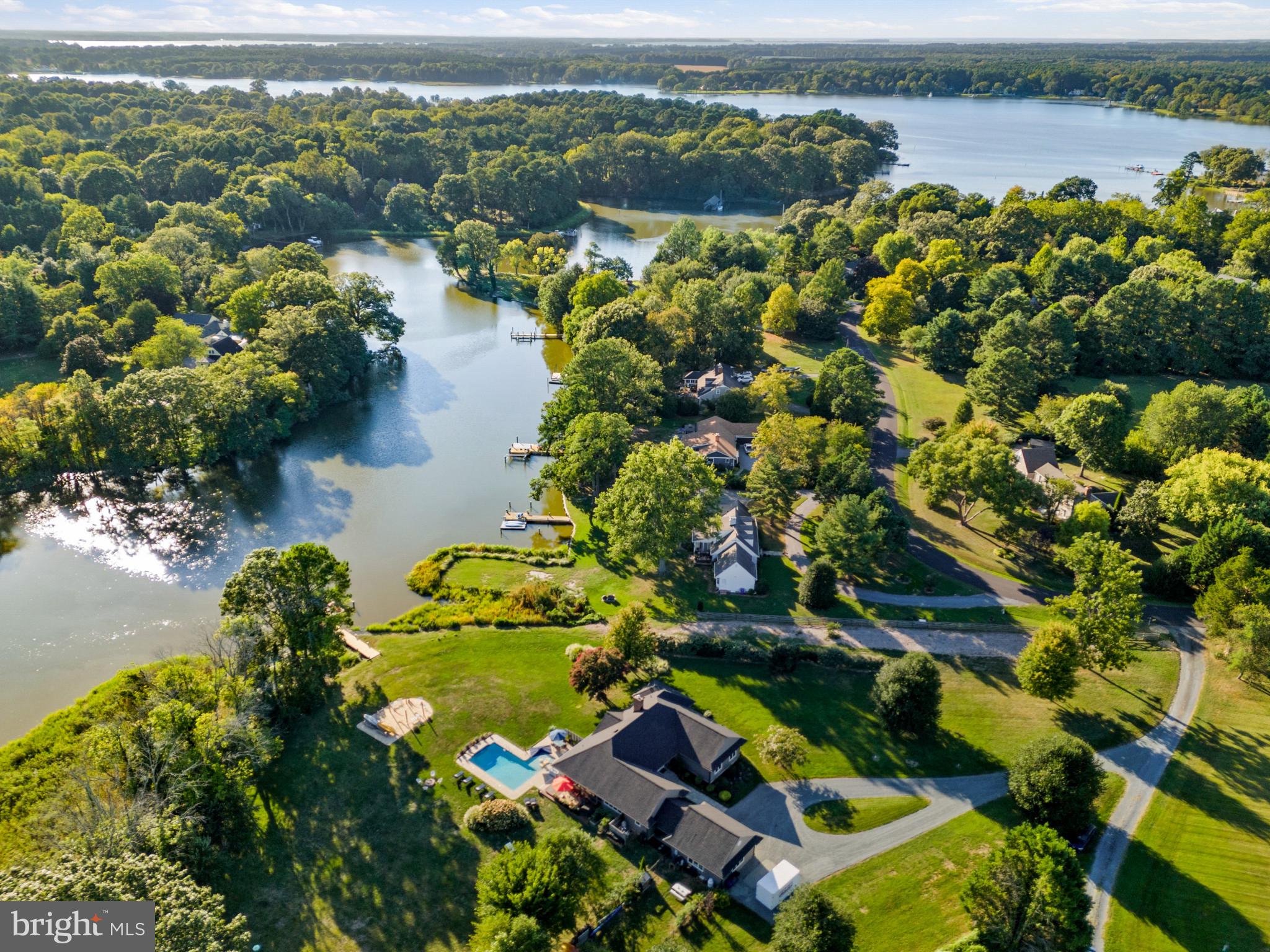 Presenting a stunning new Talbot County waterfront listing located in the sought-after Miles River community of Northbend off St. Michaels Road. Just minutes by water to the Miles, this beautiful and convenient 2700+sf one-story residence features an open concept floorplan with a wall of waterside windows providing SW sunset water views. Built in 1989 and completely renovated in 2016, this home features 3 bedrooms and 2.5 baths, high-quality upgrades including a totally new gourmet kitchen with custom Fieldstone solid wood cabinetry, GE Monogram appliances including propane cooktop (R. Brooks and Sons) and Silestone countertops; beautifully remodeled and expanded Great room with tray ceiling and energy efficient wood burning fireplace (with insert); the addition of a custom antique 1850s black walnut bar from Johnson Village, Ct overlooking Chapel Cove with commercial grade restaurant triple sink, frig and ice bin (featured on National Geographics "'Abandoned" TV series!) and all new bathrooms. No space went untouched during the complete 2016 renovation including the three spacious bedrooms, flexible light-filled den/office or potential 4th bedroom, all new Andersen casement windows and patio doors, Bluestone walkways, new Certain Teed 30-year roof, encapsulated crawl space, energy efficient insulation blow in throughout attic and the addition of a water view wrap around screen porch with Wolf composite decking. A new two zone geothermal system was added as well as numerous electrical upgrades, new PVC plumbing throughout, new well pump, custom built-in two zone interior/exterior home audio system, and 2021 Safehouse Security System. Outside, the owners added a stunning Gunite saltwater pool with built in benches, LED lighting, waterfall, and 10x12 tanning deck; a waterside “beach” area with hammocks and seating and upgraded the pier with two slips and a convenient floating kayak dock. Public sewer is under construction in Northbend which gives owner flexibility for future expansion including the conversion of the office/den to a 4th bedroom if desired. For additional information a detailed list of 2016+ improvements is attached in the document section of this listing. (Note that due to limitations of Bright input property has total energy efficient Geothermal HVAC 2016, Primary Bathroom vanity top is honed marble, flooring is porcelain tile; hall full bath flooring is porcelain tile; half bath flooring is porcelain tile and vanity top is honed marble. Bath showers all custom. Fully fenced dog run, decorative fence along northeast property line.) 2ft +/- mlw end of pier to be confirmed by buyer.