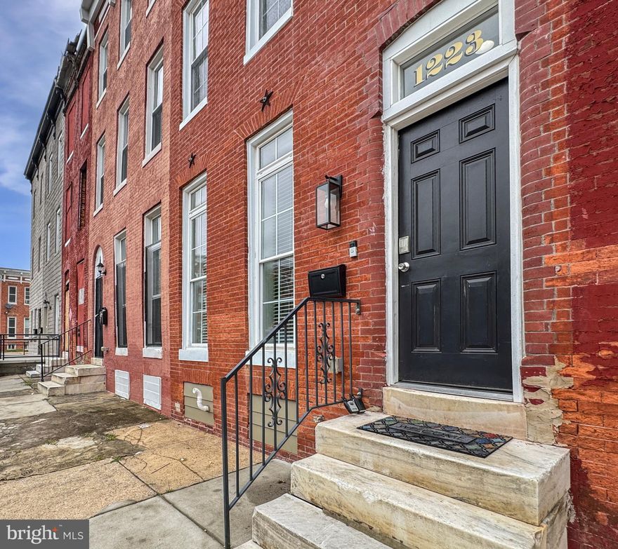 Welcome to this renovated four-story Colonial-style brick townhome in Johnston Square. Featuring 4 bedrooms and 4 bathrooms, this spacious home blends historic charm with modern updates. Original hardwood floors flow throughout, complemented by an updated kitchen with stainless steel appliances, granite countertops, and chestnut cabinetry. The living room centers around a cozy wood-burning fireplace, while the private 4th-floor suite and convenient upper-level laundry add everyday comfort. The fully finished basement offers flexible space for entertaining, a home office, or media room, with additional washer/dryer hookups. Enjoy two outdoor spaces, an upper deck and backyard balcony plus abundant storage. Located near Johnston Square Park, Johns Hopkins University, and Downtown Baltimore, this home is both a comfortable residence and a smart investment in a growing community.