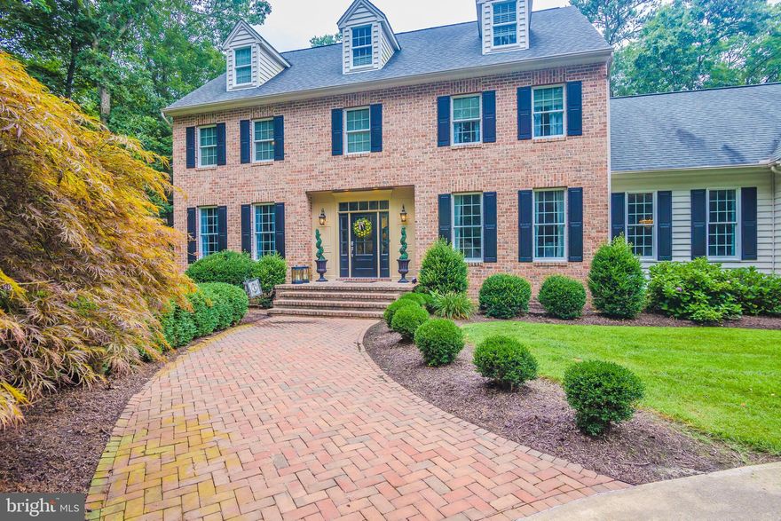 Beautifully appointed brick front colonial located on a meticulously landscaped, cul-de-sac lot features: Large, bright kitchen with  center island , granite countertops, double ovens, new cooktop, and cabinets galore.  Adjoining family room with a new fireplace insert and updated stone surround.  Rear sun room with exposed beam wood ceiling and  new barn-style sliding doors at the entry.  Formal dining room with crown and chair molding.  Master suite with large custom closet and built-in vanity.   Private guest suite on third level with  full bath, bedroom and den.  Finished basement with built-in wet bar, half bath and space for entertaining.  Newly stained rear deck overlooking the wooded backyard.  Front and rear staircases.  Lawn irrigation.  3 car garage.  Hardwood flooring/ tile 1st & 2nd levels.  Instant water heater.  And so much more!  Several new updates in past 2 years include:  Light fixtures throughout much of home.  Central vac unit.  Front entry door/side panels.  Sliding doors to sunroom.  Several toilets/faucets replaced.  LVT and carpet.  Half bath sink vanity.  Master shower frame and glass.  Freshly painted shutters.  Installed hot tub.  Heat pumps installed 2015  Additional 1152 sq ft of finished space in basement not included in total. Septic capacity for 8 full time residents