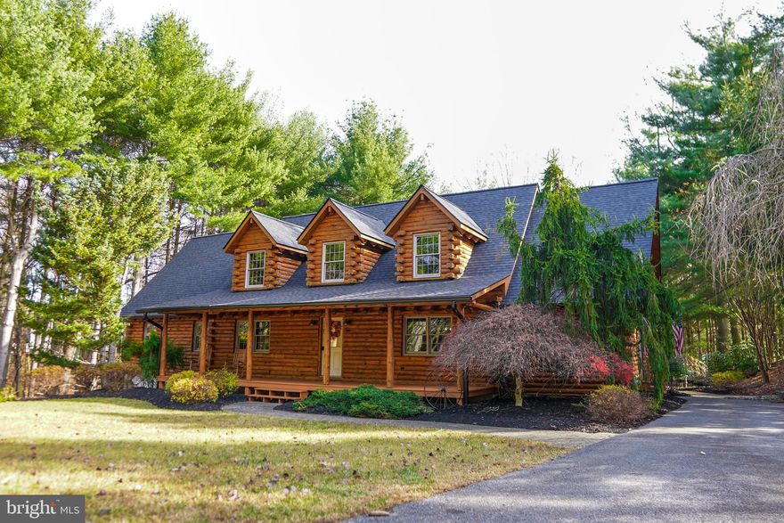 A home is a special place to relax and feel at peace. Often that feeling of “instant tranquility” when walking in the door is only felt at vacation properties. Well, Welcome to The Lodge, a true sanctuary where comfort, nature, and convenience converge. This exceptional property offers the rare opportunity to own a private mountain retreat, while still enjoying the convenience of living in the Baltimore-Metro area. Nestled on over 5 acres of pristine land, surrounded by a protected pine forest and a conservation easement that extends to the 1,900-acre Soldier’s Delight Nature Preserve, The Lodge provides an unparalleled living experience.

Built in 2000 by an experienced custom home builder for their own family, this log cabin was constructed with meticulous attention to detail and built to last. The home has been lovingly maintained and thoughtfully upgraded over the years, ensuring that it stands the test of time. When the current owner discovered this treasure, they were honored to continue its legacy.

A true masterpiece of craftsmanship, the Lodge exudes timeless charm and character. No log cabin is complete without a cozy fire to gather around, and in 2021, a brand-new Ahren-Fire fireplace and chimney system were installed in the Great Hall, perfect for warming up on those chilly winter nights. Outside, the large deck wraps around the home and overlooks a serene pond with a trickling waterfall, creating a perfect space for relaxing with a glass of wine or hosting family and friends. As the sun sets, the stone bonfire ring invites you to gather under the stars, making memories and enjoying s’mores all with the convenience of electrical outlets for added comfort.

For those professional builders, contractors or DIY enthusiast, The Lodge offers incredible opportunities with two fully equipped workshops. The oversized garage is wired with a 50 Amp hookup, ideal for large trucks or work vans. Additionally, a pole barn/shop with water lines from the spring-fed well is available for all your projects. The unfinished second-floor loft offers even more possibilities, whether you choose to complete it as a private office or another living space.

In 2022, the Lodge was transformed into a smart home, designed to offer both modern convenience and energy efficiency Three Clopy premium garage doors with Intellicore insulation technology and MyQ LiftMaster openers make it easy to control the garage doors remotely from anywhere in the world. The home is equipped with a Phillips Hue color light system, allowing you to create the perfect ambiance at the touch of a button The upgraded security system, Total Control 2.0, allows for remote monitoring and control of the entire home, from motion sensors to smoke detectors, ensuring your peace of mind whether you're home or away. With a high-performance geo-thermal system, the home stays energy-efficient year-round, keeping costs low while offering ultimate comfort.
Recent upgrades include a brand-new roof with skylights, new gutters with gutter guards, professionally sanded and resealed log exterior, all-new granite countertops, new appliances, and luxurious modern finishes that complement the timeless appeal of this custom log cabin.

The Lodge is truly a rare find—an exquisite home set in an ultra-private location with access to a nature preserve, upgraded with smart home features and energy-efficient systems. Whether you seek serenity or adventure, this property offers the best of both worlds. Don’t miss the chance to make The Lodge your own—this is more than a must see, it’s a must-buy!! Buyer to confirm all listing information.