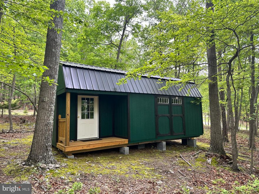 Tucked away in the scenic Lost River Ridge Subdivision, this beautiful corner lot offers the perfect blend of seclusion, accessibility, and opportunity. Surrounded by whispering hardwoods and abundant wildlife, the property features a charming 12x24 partially finished hunting cabin—ideal for weekend retreats or your future mountain hideaway. A travel trailer with electric service is already in place, offering immediate use and comfort while you build or explore. With the hard work started and only a well and septic needed, this lot is brimming with potential. Whether you're dreaming of a quiet hunting escape, a vacation basecamp, or a future full-time residence, this slice of West Virginia wilderness is ready for your vision. Don’t miss the chance to own a piece of paradise in one of Hardy County’s most desirable mountain communities.