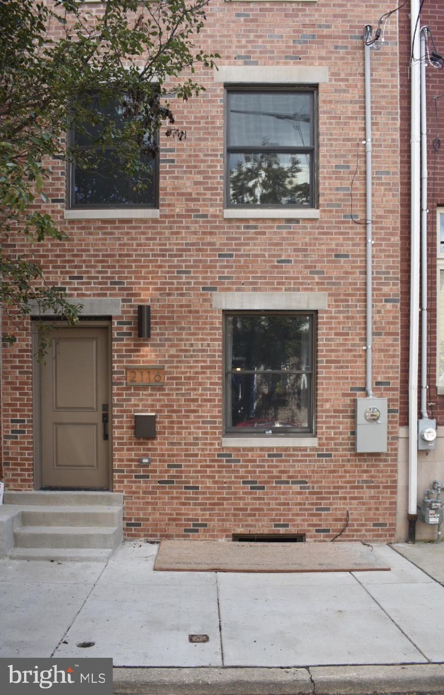 Does four floors of luxurious amenities and high end finishes sound like a dream? No corners were missed and no stone was left unturned in the polishing of this Graduate Hospital townhome. Approach a nostalgic red brick facade with a prominent steel insulated front entry door and nicely adorned address plate. Enter into a lengthy living room space highlighted with such features as freshly laid hardwood floors throughout, a generously sized front bay window for natural sun, and a nearby powder room with open air closet space for all of your guest s belongings. A stunning floating staircases with iron wrought finishes climbs this entire homes with you as your explore. The kitchen will quickly become the focal point of the main floor due to its stunning high end features and stainless steel accents throughout. A spacious granite island with barstool space, shaker cabinetry, subway tiling and a huge ranged oven with several burners are all sync with one another. Off the kitchen you can access the private, fenced in one-car slope with enough space on the sides for additional storage as well. Head upstairs to the second landing to see two bedrooms each hosting their own full bathroom with granite vanities, medicine cabinet space, and a fully tiled shower tub. The third floor is fit for royalty as this entire landing is deemed the master suite. This rand sized bedroom is flooded with natural sunlight by two large windows. Turn the corner to segway through the galley style walk through closet featuring shelves on shelves of space all of your clothes and most prized possessions. The luxury continues in the grand master bathroom, which is home to a dual, granite accented vanity, a lustrous fully tilled glass door shower stall, and a standalone soaker tub. Off the back of this suite is a private rear balcony for that added elegance and intimacy. Continue upstairs to the top of the home to find a full on wet bar with sink, a lovely backsplash, and cabinet space for all of your perfect pairings. Your drinks will be enjoyed with stunning panaromic views of Philadelphia on the roof top deck! Your nights of entertaining will never be the same once you take in all of the sights and sounds from up above.  The square footage continues as this home comes equipped with an oversized finished basement with closet space and an additional powder room for convenience. This home is the definition of prime location! The list of nearby neighborhood restaurants, cafes, shops, and local parks is too many to name. This home must be toured to fully understand the value that comes with it for years to come. All this and a Ten Year Tax Abatement! *A brand new gate with remote control access will be installed in the rear driveway.*