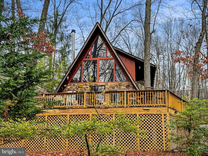 Looking for the opportunity to start an AIRBNB amidst the beauty of the mountains?  This is the place as it comes complete and ready to start renting as soon as you close!  OR step into your own slice of mountain paradise with this custom 2 bed, 1 bath 1224 sqft chalet nestled in a serene mountain setting. Are you dreaming of a place with exposed beams, warm wood floors, a cozy wood stove, a charming loft, and decks where you can soak in the symphony of nature and entertain your heart out? 
On the main level, you'll find everything you need: a snug bedroom, a convenient bathroom, and even laundry  for added ease. The cozy family room boasts soaring ceilings and a crackling wood stove, perfect for those chilly evenings. And the kitchen? It's equipped with sleek stainless steel appliances, ready for all your culinary adventures.
Head upstairs to discover a spacious bedroom, with access to it's own private balcony, a versatile loft space, and a cedar closet for all your storage needs. Need even more space? How about a two-car detached garage with a loft above, waiting to be transformed into your dream hangout or storage haven?
With all paved roads leading to your .67-acre property, parking is a breeze. Whether you're seeking a peaceful getaway, an exciting AirBnB venture, or a cozy full-time residence, this place has it all. And the cherry on top? You'll enjoy internet and cell phone service here, plus the freedom of no HOA restrictions.