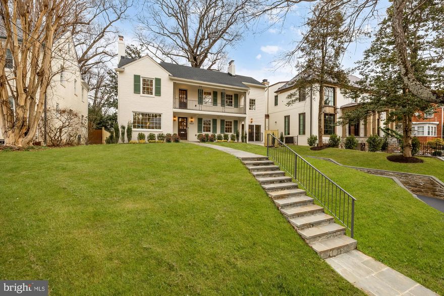 In the heart of the historic Spring Valley neighborhood stands 4827 Sedgwick Street NW, a classic 1948 Colonial set on a quiet, tree-lined street. What started as a shell has now been transformed into a modern, sophisticated new construction home that spans nearly 5,000 square feet on 4 levels. The refined reimagining is the work of Kent Construction & Development and renowned designer Lisa Najafi, names synonymous with quality craftsmanship and design integrity. A wide flagstone walkway leads to the warm and inviting facade, finished in a soft creme palette and accented with moss green shutters. Inside, there’s meticulous attention to every detail–wide plank white oak floors, solid core wood doors, generous crown moldings and door casings, designer lighting, and super luxe finishes from Waterworks, Baldwin, Restoration Hardware and Rejuvenation. Thoughtfully designed, the formal living room features a wood-burning fireplace with a restored mantel and Italian marble.  The dining room offers a dramatic lighting fixture and a large picture window that floods the space with natural light. The adjacent office and breakfast room both step down to the rear lawn, offering seamless indoor-outdoor living.  The chef’s kitchen is a culinary delight featuring custom beaded inset cabinetry with European hinges, natural stone backsplash with pot filler, and a stunning white oak island topped with a large 10-foot double-thickness Quartzite countertop imported from Brazil, ideal for entertaining.  The appliances are equally impressive–Wolf eight-burner gas range with double ovens, Subzero refrigerator with hidden fridge cabinet, two three-drawer Viking dishwashers and a Wolf microwave drawer.  The adjoining family room features a custom walnut slatted wall detail and wood-burning fireplace with granite imported from India, perfect for relaxed gatherings.  A large powder room showcases an Italian marble vanity, designer wallpaper and elegant sconces. Upstairs, the primary suite offers a serene retreat. The closet features custom cabinetry, dimmable integrated lighting, velvet-lined jewelry drawers, shoe racks and valet rods. The spa-like primary bath is outfitted in marble from top to bottom and features radiant heated floors, James Martin vanity with double sinks, a floating tub, and a walk-in glass shower with dual rain shower heads. Three additional ensuite bedrooms, one with a copper balcony, and a convenient laundry room with a full-size washer and dryer complete this level. The expansive top floor offers an abundance of flex space–ideal for a rec room, a game room, an additional bedroom or a second office. Plus, there’s lots of great storage.  Downstairs, the space is designed for entertaining, lounging and exercising.  The media room features a wood-burning fireplace, custom walnut wall detail, fluted media cabinet, 75-inch TV with surround sound system, high-end electronics and built-in shoe cubbies and coat hooks. There’s also a dedicated gym with rubber flooring and floor-to-ceiling mirrors, an additional laundry room and a fifth ensuite bedroom.  A single-car garage with security camera and remote entry complete this level.  Behind the scenes, advanced smart home systems include ADT security, video surveillance, energy-efficient Marvin windows, 80-gallon electric water heater and two dual-zone, gas-fired HVAC systems. Out back, the newly fenced backyard features mature landscaping and a flagstone patio that makes for elegant outdoor entertaining.  With close proximity to Spring Valley Village, American University, and some of the finest shopping, dining and nightlife in DC, 4827 Sedgwick Street NW not only refines urban living, it redefines it.