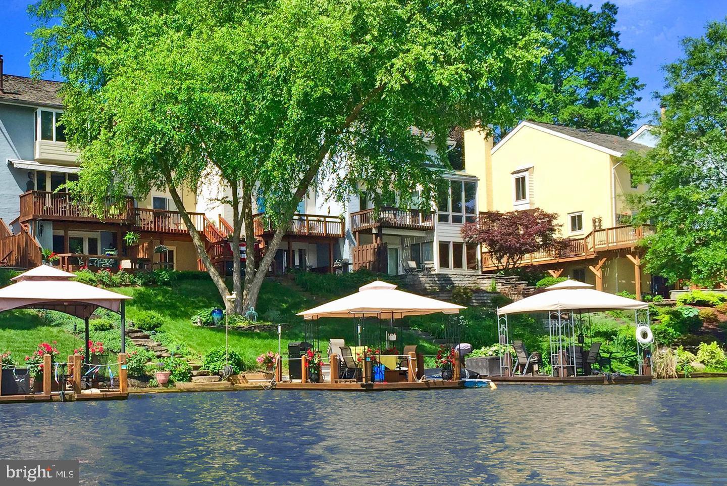 End Unit with large lake front views and private lake front with private dock boat and private front court yard. The main level offers hardwood floors, sunken living room with private side deck, balcony facing the lake, breakfast room, Renovated gourmet kitchen , wet bar and wine fridge, updated stainless steel appliances and dining area with sweeping views of Lake Thoreau and serenity abound. The upper level offers a large primary suite with views of the lake, updated primary bath and converted 3rd bedroom to large walk in closet. large 2nd bedroom and updated guest bath! The lower level offers an additional bedroom and full bath, huge recreation room and bump out with access to rear lower level deck, hot tub and gorgeous lake front! The tiered landscaping creates a dramatic entrance to the lower level lake private lake front with 3rd patio and private dock .