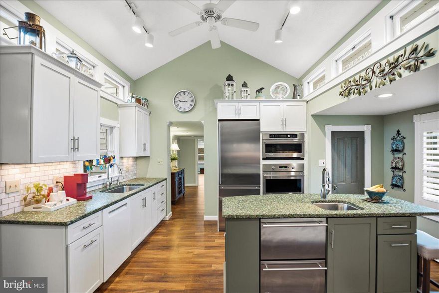 COASTAL LIFESTYLE IN THE AVONDALE NEIGHBORHOOD OF SOLOMONS -A 6BR/5BA RARE FIND! TWO DWELLINGS NEAR MARINAS, RESTAURANTS AND BOARDWALK. PRIMARY RESIDENCE W/ MAIN LEVEL OWNER'S SUITE (2160 sq ft) +  GUEST HOUSE WITH TWO DISTINCT UNITS (1632 sq ft).  INCOME POTENTIAL.  Yesteryear charm meets modern quality in this beautifully updated home located in the heart of Avondale. The main residence has 3BR, 3BA with main level primary suite addition, and the separate guest house has a 2BR/1BA apartment on upper level, 1BR/1BA studio with wet bar on lower level. Thoughtfully updated while preserving its character, this property delivers comfort, style, and exceptional versatility. Inside, luxury vinyl plank flooring adds durability and a fresh look throughout the original waterman's cottage. You'll appreciate the updated spaces and quality additions over the years, full of architectural details. The chef’s gourmet kitchen is a true showpiece, featuring very unique designer countertops with colored glass, GE Monogram appliance package with warming drawer, wall oven, gas cooktop with built-in griddle, counter depth refrigeration, 2 additional refrigeration/wine chiller drawers, GE Advantium microwave-convection unit — all designed for elevated cooking and effortless entertaining. Abundant cabinetry and generous prep space complete this impressive culinary setting. Adjacent dining room can host dinner parties and holiday gatherings, and the sweetest breakfast room or den connecting kitchen to the large screened porch is provides a very livable and comfortable plan for the village lifestyle. A standout feature is the private primary suite, bathed in natural light and designed for true comfort. The spa-inspired primary bath includes large dual vanities with granite counters, a zero-threshold roll-in shower, and heated tile floors — seamlessly blending luxury and thoughtful accessibility. Relax on the screened porch overlooking a tranquil courtyard garden, established by a master gardener — your own private retreat with stone patio and a vintage shed building which may have multiple uses. Incredible guest building: the detached 1,632 sq. ft. building offers extraordinary flexibility and has its own parking, private outdoor living spaces. The upper level features a 2-bedroom, 1-bath apartment, while the main level includes a 1-bedroom studio with a wet bar. Perfect for guests, multigenerational living, rental income, home business, or creative space. Rare opportunity. Prime location. Multi-unit flexibility.