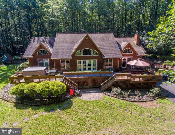 Beautiful secluded log home w/carriage house and small horse barn on 16.6 acres. This home is a masterpiece of wood & stone w/exposed beams, fireplaces, cathedral ceilings, circle top windows, skylights & more! The main level features a 2 sty. great rm. w/stone gas FP & French doors leading to front deck; eat-in kitchen w/granite countertop, island w/bar seating, stainless steel range, French door refrigerator, wall oven, warming drawer, microwave and dishwasher; Laundry w/W&D, closet & door to rear deck; Master Bedroom w/brick gas FP, walk-in closet w/closet system & door to deck and hot tub; Master bath w/tiled floor; glass shower & jetted tub. The upper level consists of 2 bedrooms, both with exits to a 5’x30’ deck; a full bath; and attic storage. The lower level is a great place for entertaining w/a large rec room w/stone gas FP, wet bar and a half bath; 2 bonus rooms (could be bedrooms); a utility room; and outside exit. The home has a front, rear & side deck consisting of approx. 1,482 SF w/a large hot tub, propane forced air heat w/central air, 5 heat zones, central vacuum, on site well and septic, 40 kw generator, and 1,000 gal propane tank. The property also contains a 14’6”x 40’ log Carriage House w/2 fully finished rooms, one w/cathedral ceiling, one w/stone gas burning FP and storage w/overhead garage door on one end and a stage/deck on the other; 12’ x 28’ Horse Barn w/ stable and tack/storage w/overhead garage door; spring-fed, fully stocked self-cleaning Ponds w/trampoline,
fountains, bridges, a large composite diving deck, lights and more, all accessed by a stoned pathway crossing over French Creek.
The property is a secluded retreat & hobbyist’s paradise backed by 237 acres of State Game Land! With a paved driveway, numerous decks and patios for relaxing, a water garden, a fenced back yard for pets, large playset, raised beds for planting, hiking/riding trails, swimming, excellent hunting & recreational fishing and a great place for entertaining as well. The property is in good condition with a few areas needing TLC to make it shine.