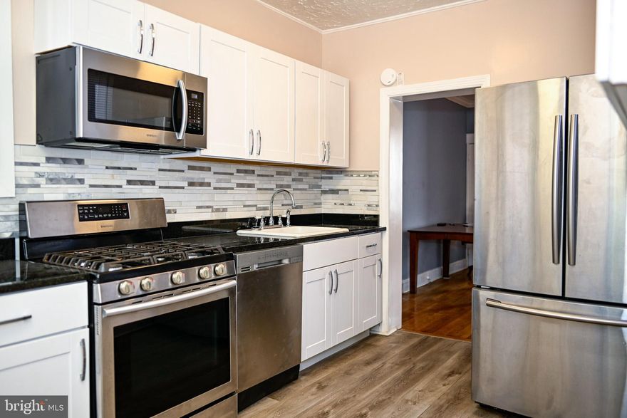 Charming Renovated Townhome Near Johns Hopkins University!
Perfect for first-time buyers or savvy investors, this updated 2-bedroom, 1-bath home blends historic Baltimore charm with modern convenience. Step inside to find gorgeous hardwood floors, tall ceilings, and crisp crown molding that add character throughout.
The renovated kitchen shines with sleek black granite countertops, mosaic tile backsplash, and new vinyl plank flooring, opening directly to a rear area that could be for parking or a yard.  The full bathroom has also been stylishly refreshed, making the home truly move-in ready.
Additional highlights include fresh paint, security doors, a welcoming front porch on a tree-lined street, and both front lawn and a rear patio. The finished lower level offers extra living space, a separate toilet, laundry area, and plenty of storage.
Located close to Johns Hopkins University, shopping, and commuter routes, this home is a fantastic opportunity to own in a vibrant neighborhood.
