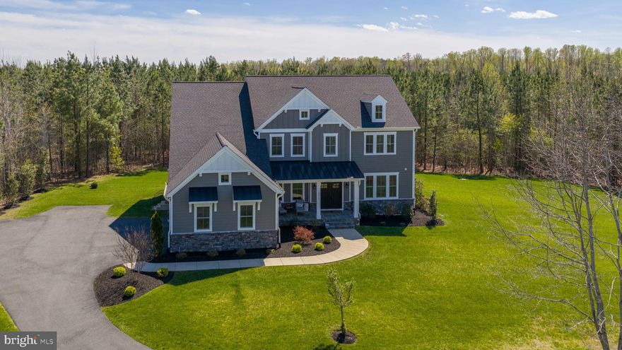 Welcome to 10912 Downton Avenue—an exceptional custom estate nestled on 5 private, wooded acres in the sought-after Fortunes Landing community of Spotsylvania. Built in 2022 by the renowned and award-winning Simply Home, this stunning residence offers over-the-top craftsmanship, thoughtful design, and the perfect blend of luxury and everyday comfort.

From the moment you arrive, the home’s commanding presence and peaceful natural setting make a lasting impression. Step inside to discover white oak hardwood floors flowing throughout the main living areas and a breathtaking two-story living room, where soaring ceilings and exposed wood beams create a dramatic yet inviting focal point filled with natural light.

At the heart of the home, the gourmet chef’s kitchen is designed to impress and perform—featuring an oversized island, gleaming quartz countertops, custom soft-close cabinetry, and a spacious walk-in pantry. Whether hosting gatherings or enjoying a quiet evening at home, this space seamlessly connects function and style.

The main level also offers incredible flexibility with a private bedroom suite—perfect for guests or multi-generational living—as well as a large, dedicated home office ideal for remote work or creative pursuits.

Upstairs, the luxurious primary suite serves as a true retreat, complete with a spa-like bath and a thoughtfully designed walk-in closet. Three additional spacious bedrooms complete the upper level, including one with its own private bath and two connected by a convenient Jack-and-Jill bathroom. A generously sized laundry room adds ease and efficiency to daily living.

The finished basement expands your living space even further, offering an expansive recreation room perfect for movie nights, game days, or entertaining. A private guest suite with a large bedroom and full bath provides comfort for visitors, while a substantial unfinished area offers endless possibilities for storage or future customization.

Outdoor living is just as impressive, with a composite deck overlooking the tranquil, wooded surroundings—an ideal space for relaxing, entertaining, or simply enjoying the beauty of nature.

Located in the serene community of Fortunes Landing with access to the Ni River Reservoir, this property offers the rare combination of privacy and convenience—just a short drive to the shops, dining, and historic charm of Fredericksburg.

10912 Downton Avenue is more than a home—it’s a lifestyle defined by space, craftsmanship, and connection to nature.
