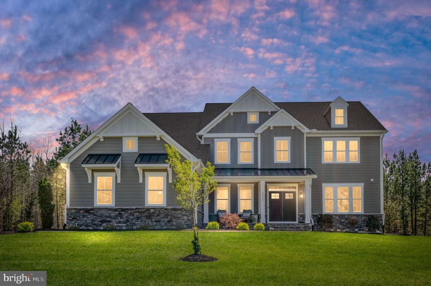 A gently curving 250-foot driveway leads you up to this stunning Simply Home–built colonial, set on a hilltop overlooking 5 acres of beautifully maintained grounds. Mature trees form a natural perimeter around the property, creating a peaceful, private refuge that feels worlds away — yet sits just minutes from area shopping, dining, schools, and I-95. From the moment you arrive, this home delivers something rare in today’s market: space, privacy, and craftsmanship.

The stacked stone facade and generously sized covered flagstone front porch set the tone before you ever step inside. Enter through the foyer and you’re greeted by an abundance of natural light, nine-foot ceilings on all three levels, white oak hardwood floors, and refined details throughout. The dramatic two-story family room with box beam ceilings is the centerpiece of the main level, and the bright sunroom offers a quiet retreat for morning coffee or evening reading. A dedicated office with a spectacular view provides the ideal work-from-home setting.

The heart of the home is a gourmet kitchen designed for both everyday living and entertaining, featuring an oversized island, farmhouse sink, walk-in pantry, and soft-close cabinetry. You’ll find that same soft-close quality carried throughout the bathrooms and laundry as well. A side-entry double drop zone adds the kind of thoughtful, functional space busy families actually use. The flexible floor plan offers an owner’s choice primary suite on either the main or upper level — both featuring bathrooms with double vanities and walk-in showers — giving you the freedom to tailor the home to your lifestyle. The upstairs primary suite takes it a step further with a luxurious spa-like bath and an extra-large walk-in closet. In all, five of the six bedrooms feature private en suite bathrooms. Upstairs you’ll also find a convenient laundry room, generous closets with custom wood shelving, and premium tile finishes throughout all bathrooms and laundry.

Step out onto the Trex deck and take in sweeping views of the backyard and stunning sunsets that make this property feel like a private retreat. The grounds are supported by a 22-zone irrigation system that keeps the lawn lush and green with minimal effort, and a whole-house water filtration and softener system ensures quality water throughout.

The mostly finished walk-up basement extends the living space with a huge recreation room, an additional bedroom, one full and one half bath, and direct walk-out access to the backyard — perfect for multigenerational living, a home gym, or a dedicated entertainment level.

Designed with both luxury and practicality in mind, this home also features a 3-car oversized garage with EV charger, pre-wired generator hookup, and 6 bedrooms with 7 bathrooms across three finished levels — offering the flexibility for dedicated home offices or generous guest accommodations.

Fortunes Landing is a premier 315-acre estate community by Simply Home, situated along the Ni River Reservoir. Residents enjoy community access to the reservoir for fishing, canoeing, and paddle boarding, along with paved walking and biking trails and a private community center with sport court. Surrounded by nature yet conveniently located near Old Town Fredericksburg, Spotsylvania Towne Centre, Wegmans, and top-rated medical facilities, this is the rare home where you truly can have it all.