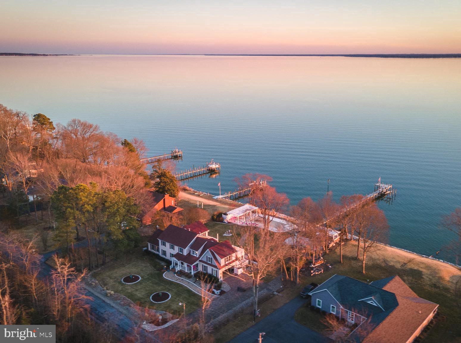 Custom waterfront home on the Potomac River with breathtaking panoramic views. Designed for both family living and entertaining, this spacious residence boasts a thoughtfully remodeled gourmet kitchen by St. Maries Builders, a family room, sunroom, living room, and a large den with a full bath on the main level. Expansive windows maximize natural light and showcase stunning sunsets.
The upper level features four bedrooms, three full baths, and a versatile sitting room or office, with multiple rooms offering access to private balconies.
Outdoor highlights include a newly renovated Gunite pool with custom tile, a gazebo, a screened porch, a travertine deck, an outdoor kitchen with a new grill, and a firepit. The private pier has water & electric and features a boat lift. The shoreline is protected with riprap. The professionally landscaped grounds also include a paver driveway, high-speed internet, and a generator for peace of mind.