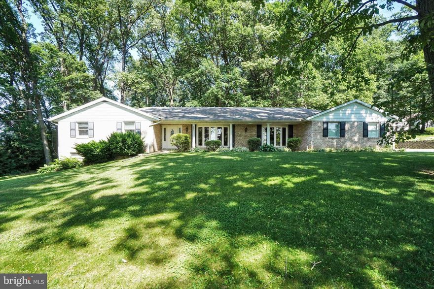 This private wooded 1.9 acre setting offers a spacious 3 bedroom, 2.5 bath all brick rancher convenient to either East York or Red Lion, I83, Rt30, schools, shopping, recreation and more.  Wonderful combination of traditional and casual living!  Large living room and separate dining room both finished with crown molding lead to the kitchen and cozy breakfast nook where you can watch nature from your bay window.  Kitchen is open to the family room with hardwood flooring, brick fireplace and pine wainscoating, great area to gather and entertain!  Primary bedroom has adjoining bath and double closets.  2 additional good sized bedrooms and hall bath, perfect for children or overnight guests.  Lower level offers rec room with bar, utility room and huge workshop/storage area with tractor garage.  Additional features include walk up attic, whole house back up generator, security system, Cinch home warranty and lovely screened in porch off driveway.  To top it all off is the view of a serene horse farm across the street!