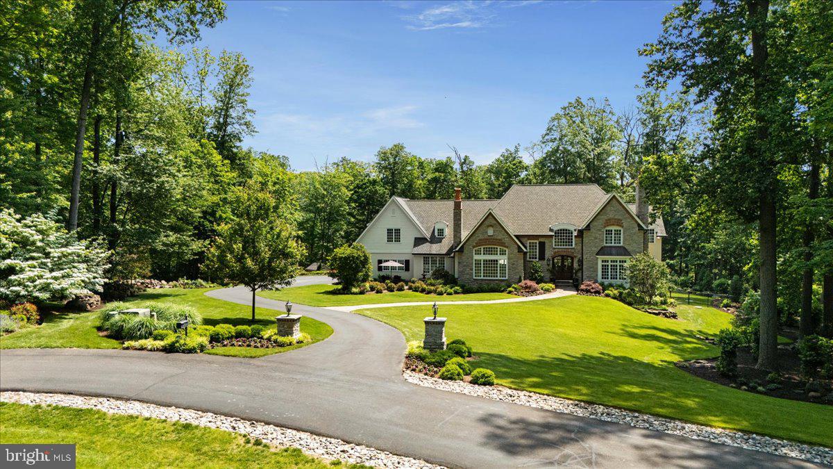 Nestled in the prestigious rolling hills of New Hope, a winding private lane leads through exclusive breathtaking Zaveta built Custom Homes. Elevated above the Delaware River, along a quiet cul de sac, the manor style home at 412 Rockwood Path invites you with stately stone columns and an exquisitely manicured 3 acre landscape. Built-in 2007, this home's custom design incorporates European inspired exterior featuring pitched roofs, architectural shingles with soaring windows that are adorned by stone and brick arches. The grand entryway invites you in through double mahogany and glass arched French doors, to a stunning 2-story marble foyer beneath a captivating chandelier. Superior construction in every aspect of the house is evidenced by custom cabinetry and millwork, masonry fireplaces, true divided light windows and site finished oak floor throughout. The main living area encompassing the kitchen, breakfast and great room contains intimate spaces defined by fluted columns. The great room features a vaulted ceiling framing a Palladian style window, built-in media cabinet and a cozy window seat adjacent to a stone fireplace. The entire home includes Sonos surround sound system throughout as well as the back yard. The breakfast area includes a bank of windows and garden door to a bluestone patio with a fountain perfect for that morning coffee! The kitchen is separated by a large island with seating, cabinets, and a vegetable sink. A farm sink is tucked into cherry cabinetry with granite counters with a beautiful view of the back yard, pool with wooded border with a custom built raised vegetable garden. Kitchen appliances include a commercial gas range, secondary wall oven, microwave, and SubZero refrigerator. The main floor includes an executive office and powder room, as well as a secondary living room with wood-burning fireplace. The central portion of the home is anchored by the formal dining room with an adjacent wet bar and butler’s pantry, boasting custom designed cabinetry and solid cherry counters and shelving. A secondary staircase off the kitchen leads you to 3 spacious unique bedrooms and 2 full baths. The master bedroom suite is separated from the additional living quarters by French doors at the end of a wide and well-lit hallway, which overlooks the living room and foyer. Separate walk-in custom closets, the primary suite also includes a large and comfortable seating area with backyard views. The primary bathroom features marble throughout, including a walk-in shower and jacuzzi, as well as a large and private water closet.  The finished walk-out lower level is truly an amazing entertainment floor. The lower living area also offers a fireplace, surrounded by built-in cabinetry and solid walnut floating shelves. A fitness room and 6 person theatre with a kitchenette with soapstone sink, convection microwave, dishwasher and wine cooler. A large storage room is available as well a mechanical room. A 5 th  bedroom with a full bathroom was converted to additional open space but could be closed off again if desired that could provide the option for independent downstairs living. Walk out from this lower level to the grand fenced in backyard with a gorgeous terraced bluestone patio with outdoor fireplace and dramatic landscaping overlooking a heated salt-water swimming pool with gorgeous waterfall and in-ground spa/hot tub. There is so much to appreciate in this over 7000sft custom home that features high ceilings, front and back staircases, spacious open layout and exquisite finishes. The meticulous grounds and gardens are maintained by a programmable irrigation system so you can relax and enjoy this one-of-a-kind destination with amazing park-like settings including gorgeous winter views of the Delaware River. Solebury Township in Bucks County is an award-winning New Hope Solebury school district. A work-from-home dream custom home and just a 75-minute drive to NYC and 40 minutes to Philadelphia.