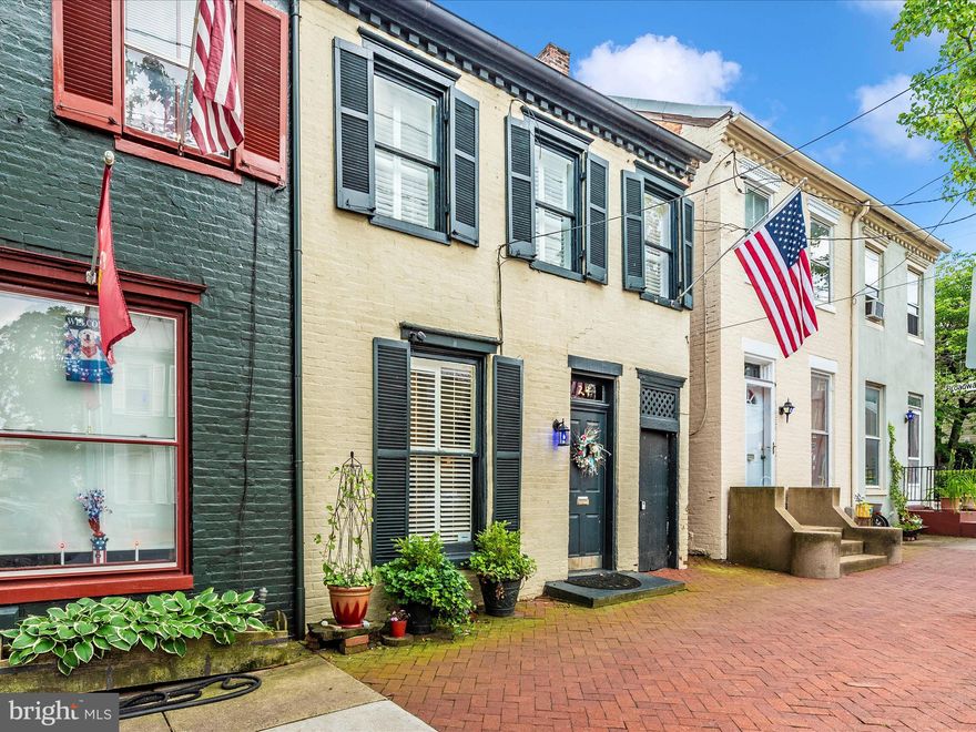 Live in the Heart of Downtown Frederick! This beautifully restored brick townhouse, built in 1850, is just steps away from Frederick's thriving retail and business district. Lovingly restored to its former glory, this charming home blends classic elegance and modern comforts. You'll find beautiful hardwood flooring and trim, plantation shutters, and exposed brick walls throughout. The welcoming foyer features hand-painted flooring, leading to a spacious living room with built-ins and a separate dining room. The main level includes a quaint powder room, a fully equipped kitchen with upgraded countertops, and faux-painted walls. The upper-level bedrooms boast exposed brick walls, high ceilings, a balcony overlooking the rear yard, ample storage space, and a washer and dryer.   The full bathroom is adorned with linen subway tile and tumbled marble flooring. Enjoy the outdoors in the nicely fenced rear yard with a patio. The home has been operating as an Airbnb since 2018 and provides many functional conveniences such as smart thermostats, smart door lock and commercial-grade Wi-Fi.  Off-street parking is available right across the street from a private lot. All furnishings convey, and Airbnb financials are available under NDA. This historic townhouse combines classic charm with modern comforts, making it an ideal home in the heart of Downtown Frederick!