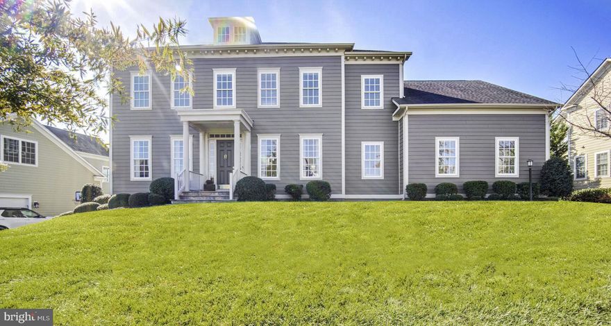 This alluring home of elegant charm is matched only by its setting in picturesque Willowsford, where farm-life community and luxury amenities have earned national awards and “World’s Best” distinction. Softly hued clapboard and welcoming historic detail introduce interiors graced by the previous owner’s superb professional design talent. Discover natural light beautifully highlighting arched transitions, sophisticated moldings, high-fashion fixtures, premium hardware, slideaway doors, and designer wallpapering in spaces for work, dining, entertainment, and rest. In your sky-high greatroom, with stone wrapped fireplace and refined coffered ceiling, invite holiday guests to gather, and pour drinks before dinner under the dining room’s lavish chandelier. Spend weekends enjoying neighborhood amenities then grab produce from the community farm stand for recipes completed in your gourmet kitchen of custom cream colored cabinetry, bespoke butlers pantry, walk-out breakfast nook, and professional-grade appliances. Outside, a pair of covered patios allow for quiet conversation overlooking play on the .33 acre lot of greenspace with professional landscaping. When ready for rest, settle guests in the sunny main level bedroom, and recover upstairs where four additional bedrooms and three baths soothe. In the primary suite, escape for a Sunday afternoon accommodated by your oversized walk-in closet, sitting room, and tranquil place for bubbles. While on tour, visit the three car garage and note the irrigation system, family room sound system, upper level laundry. In the unfinished lower level, imagine the rec room/wet bar, full suite accommodation, or creative haven of your dreams. Willowsford’s lush community appeals to nature lovers and those with discerning taste alike featuring a working farm, nature conservancy, Michelin Star-style teaching kitchens, resort pools, kayaking, architecturally recognized clubhouses, inviting children’s play areas and more.  The nearby, Brambleton shopping center offers shops, dining, and entertainment .  Commuter friendly location close to the 267 Toll Road, RT 50,  and Dulles International Airport.