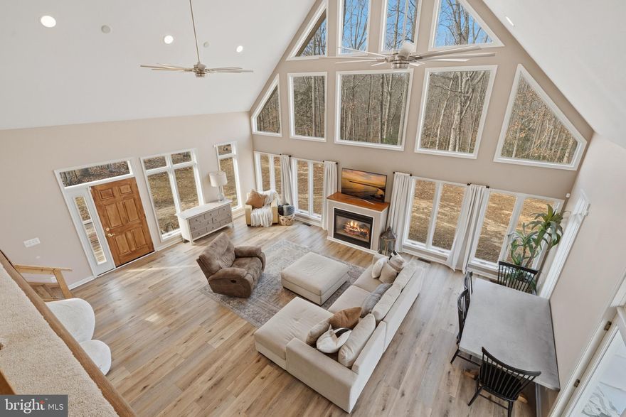 Simply Stunning! This custom-built retreat set on an extraordinary 18.58-acre wooded homestead in the heart of Mechanicsville is ready to welcome you home. Offering approximately 2,200 square feet of living space, this beautifully designed residence features 3 bedrooms, 2 full bathrooms, and two fireplaces—creating a warm and inviting atmosphere throughout. Step inside to a breathtaking two-story great room highlighted by soaring vaulted ceilings, dramatic architectural windows, and abundant natural light with peaceful wooded views from nearly every angle. Wide plank flooring flows throughout the home, adding timeless warmth and cohesion. The open-concept layout seamlessly connects the living, dining, and kitchen areas—perfect for everyday living and entertaining alike. A cozy fireplace anchors the great room, while oversized windows and glass doors invite the outdoors in and provide easy access to the surrounding nature. A loft-style upper level adds character and flexibility, overlooking the main living space and showcasing striking exposed beams and modern ceiling fans. The primary suite is a true private oasis, occupying the entire second floor and featuring a walk-in closet, private deck and attached full bath—your own serene retreat at the end of the day. Thoughtful upgrades include a reverse osmosis water system for clean drinking water, an HVAC air purifier for enhanced indoor air quality, and a 10KW generator with separate hookup for added peace of mind. The expansive property also includes a storage shed ideal for tools, equipment, or hobbies. Whether you’re seeking privacy, space to roam, or a peaceful escape surrounded by nature, this exceptional property delivers the perfect blend of comfort, craftsmanship, and country living. A rare opportunity to own nearly 19 acres in Mechanicsville—don’t miss your chance to make this private oasis your own. No HOA!