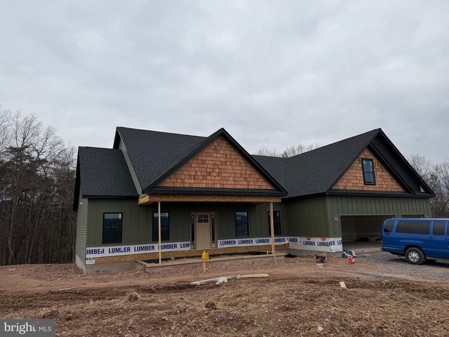 The house is in the process of being drywalled.     Welcome to this beautifully designed new construction home located on 2.9 private acres along Libby’s Ridge Road in scenic Berkeley Springs. The main level offers a spacious and functional layout featuring 3 bedrooms and 2.5 bathrooms, including a comfortable primary suite. The cathedral ceiling in the family room creates an open, airy atmosphere, perfectly complemented by a modern kitchen with stainless steel appliances, granite countertops, and ample cabinet space.
Upstairs, a finished bonus room adds incredible versatility.  Imagine a game room, movie room, office, etc.  
The home also includes an unfinished basement, ready for future expansion or storage, and a 3-car garage with garage door opener for added convenience.
This property blends quality construction with a peaceful, wooded setting—perfect for anyone seeking privacy while still being close to the amenities of Berkeley Springs.