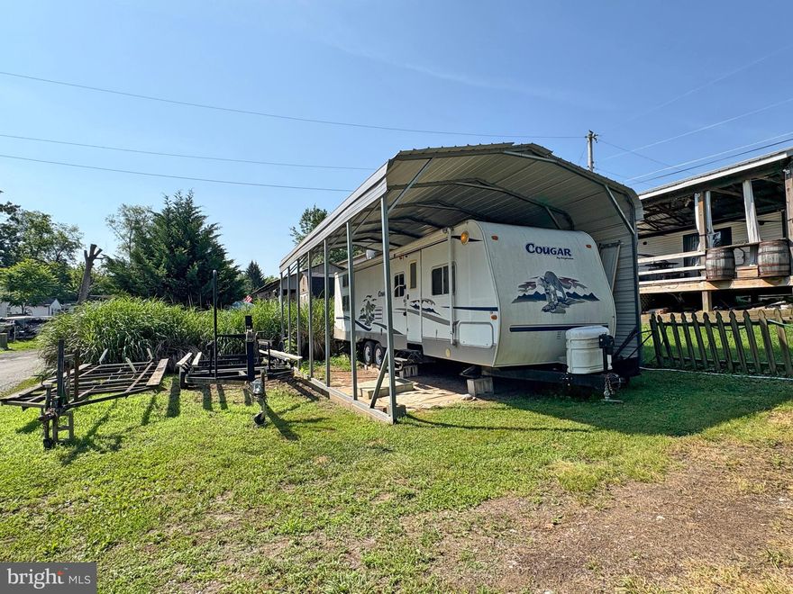 Lot 6-20 in River Bend Park is a well-appointed RV lot located just across the street from the river, offering a spacious setup ideal for seasonal living. The lot includes a 2005 RV under a sturdy RV cover and features room for additional trailers, dock/boat storage, or extra parking. Situated in a gated community open seasonally from April 1 to November 1, the annual dues are $1,775 and cover electricity, water, trash service, and holding tank pump-outs. River Bend Park offers a wide range of amenities including bath houses, laundry facilities, camp store, tennis and basketball courts, miniature golf, restaurant, and rentable pavilions. Lot will not be sold without the RV. All visitors must check in at the guard shack and be accompanied by an agent or owner to access the property. There are 2 additional lots available for sale across the street - MLS# - WVBE2041960 & WVBE2041964.