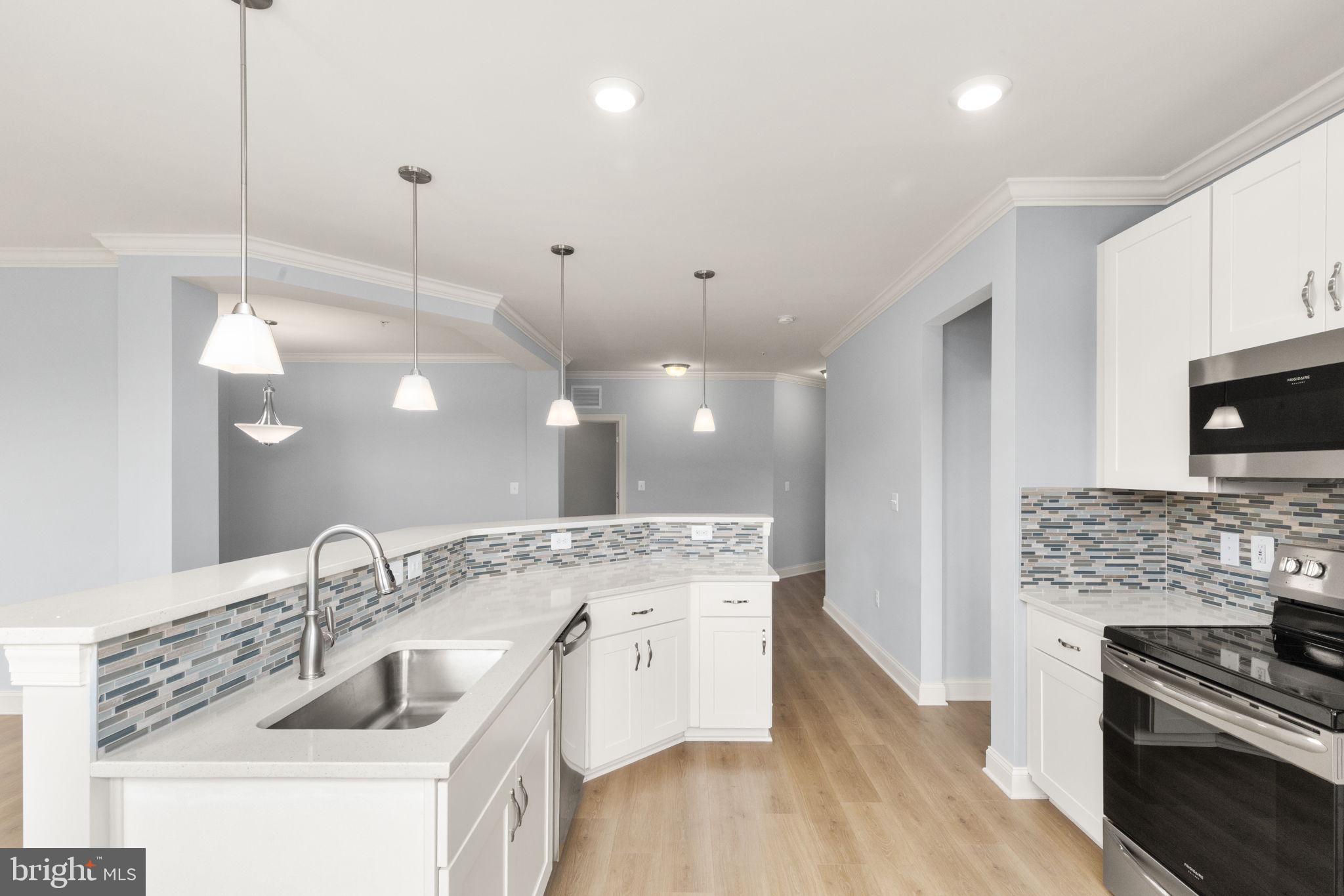 Welcome to 636 Wallingford Rd, Unit 2H! This meticulously maintained corner unit in the sought-after 55+ community of Overlook at Gateway offers peaceful, maintenance-free living in the heart of Bel Air. Built in 2020, this gorgeous home still feels brand new. Featuring the larger Emmorton floor plan with 1,800 sq ft, this 2-bedroom, 2-full and 1-half bath condo, plus full-sized den, is flooded with natural light thanks to its corner-unit orientation and abundant windows. Enjoy 9-foot ceilings in the open-concept layout, where kitchen, living room and dining room flow naturally together. The stunning kitchen boasts upgraded quartz countertops, tile backsplash, and immaculate stainless steel appliances. The bright living room leads to your private balcony overlooking the serene woods and the Ma & Pa Heritage Trail. The oversized primary suite includes walk-in closet and en-suite bath with dual vanities, and a walk-in shower. The Overlook at Gateway community provides benefits including a fitness center, outdoor gazebo, and beautiful common room for clubs and gatherings, of which there are many! Additional features include: Reserved parking space in the secure underground garage, extra storage space, elevator access and building security features. Enjoy active, low maintenance, easy living in a premier location with nature at your back door and every convenience nearby including shopping, dining, and easy I-95 access. Don’t miss this opportunity!