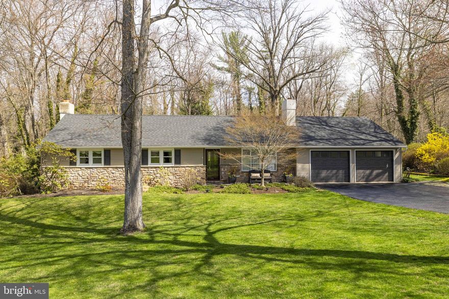 Welcome to this exceptional Bucks County ranch home, featuring four bedrooms and four full bathrooms. Located just a mile from the shops, restaurants, and museums of Doylestown Boro, this property offers a prime location paired with high-end finishes. The main level boasts beautiful hardwood flooring throughout, custom millwork, and solid doors, while the living room is centered around a striking stone fireplace with built-in cabinetry and a Mercer Tile hearth. The home is designed for both comfort and entertaining, featuring a beautifully appointed kitchen with quartzite counters, antique pendant lighting, a brand-new stove and a newer Bosch dishwasher that opens into a spacious dining room. The dining room offers a large entertaining space featuring a wine closet with a full staircase and easy access to attic storage. The French door leads to a spacious deck perfect for outdoor dining and entertaining. Functional spaces include a pantry closet along with a large butler’s pantry and laundry room with ample storage and dedicated mudroom entry from the garage. The floor plan is thoughtfully laid out with a main bedroom suite set privately on one side of the house with a remodeled bath and large windows offering sweeping views, while the other side features three additional large bedrooms, including a princess suite and a hall bath. This property is exceptionally well-suited for multigenerational living, offering a unique opportunity to accommodate diverse lifestyle needs within a single residence.
The daylight lower level adds significant versatility, equipped with a second stone fireplace, a kitchenette, a bar, and a full bathroom. This space can easily serve as an in-law suite with its own private entrance from a paved patio. Additionally on this level is a game room, gym, or home office with loads of storage closets. Outside, you will find a stunning, private backyard with a stream and professional hardscaping, lighting and a salt water spa along with a deck featuring glass railings to enjoy views of the perennial gardens and local wildlife. 
This home has been lovingly maintained and fully updated, including the roof (2022), air conditioning (2014), garage doors (2022) and driveway (2023), ensuring it is move-in ready. A new septic system was installed in 2005. A portable generator with transfer switch and a security system provide ease of mind. Located in the award winning Central Bucks school district and close to trains and commuter roads. Attention to detail reflects the care and pride of ownership throughout this Central Bucks County home making this a must see property.