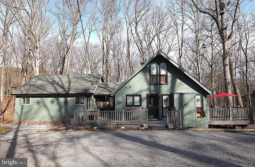 Beautiful Chalet in the desirable Woods Resort! Popular Elmwood style home on a private 1-acre wooded lot - 2 bedrooms, open floor plan, living room with floor to ceiling windows and a cozy woodstove, and a huge multi-purpose room that provides wonderful opportunities for additional bedrooms or a family/rec room. Knotty pine ceilings and engineered hardwood floors throughout the main living areas. The unfinished basement provides tons of storage space. Plenty of space to enjoy the outdoors with the screened in porch area, the wraparound porch, side deck, rear Trex deck, and the lovely fenced in yard. The Woods Resort spans over 1,800 acres of lush forests and rolling hills, perfect for relaxation or outdoor enthusiasts and is known most for its spas and golf course.