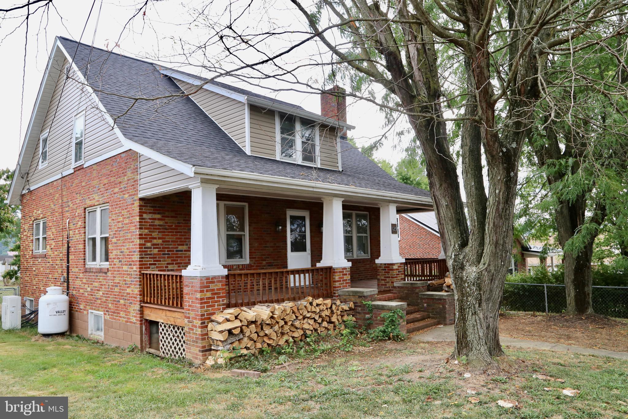 Nestled in the quiet town of Petersburg, WV you will find this 1945 built 3BD/1.2BA brick Cape Cod home sitting on 2 lots totalling 0.36 AC. Inside you will find original hardwood floors with updates in bedrooms and bathrooms and kitchen of LVP flooring. There is a wood burning stove fireplace insert with a built in fan, pictured firewood included in sale. There is a 4th main floor bedroom that previous owner moved washer and dryer hook-up to for convenience, but easily move the washer and dryer back to basement to restore a 4th bedroom on the main floor. There is a spacious kitchen that could have even more cabinets added for more storage and convenience. Off the kitchen you will find a stairway leading to a full unfinished basement that houses all utilities for the home. There is a gas water radiator heating system in home that Seller has not used in ownership. Seller had a ductless mini-split system installed when purchasing home 2 years ago, and uses wood heat as secondary source. Outside you will find a level spacious yard with a fruitful grape vine and flowering trees. There is a spacious shed for wood storage or a work shop, or added storage. The shingle roof is only 3 years old. The large front porch is perfect for relaxing and entertaining with a propane hook-up for a grill. There is a large sun porch attached in rear of home for housing your plants or relaxing. Nearby you can shop a historical local depot that has West Virginia candles, gifts, and coffees, etc. You will also find a local bowling alley, fishing and hiking at Spruce Knob Lake, cave tours at Smoke Hole and Seneca caverns, a local meadery and winery and much more! Make an appointment today!