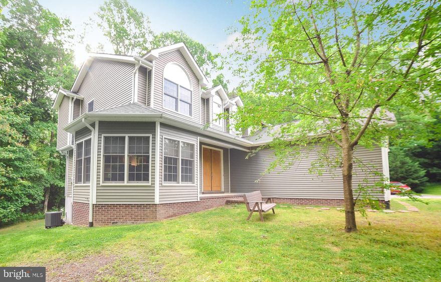 Craving privacy, acreage, a lovely custom home? The trifecta is here! Nestled in the woods, this beauty boasts upgrades like built-in bookcases, crown molding, slate flooring, and a pretty bay window. You'll find easy-to-use living space on the main level: living room with gas fireplace; kitchen with custom pine cabinetry, recessed lights, stainless appl's; spacious dining area with room for desk/computer as well. Laundry/half bath nearby for convenience. Oak staircase to upper level: nice-sized primary BR has cathedral ceiling, walk-in closet, bath has jetted tub & shower. 3 more BRs plus hall bath complete the upstairs. Lower level is finished with L-shaped rec room, den/BR, 3rd full bath. Deck recently restained, just in time for summer fun. 2-car attached garage plus 2-car detached garage w/wood stove & electric. Oakville-area location great for commuting north or south! Come see--you'll love it!