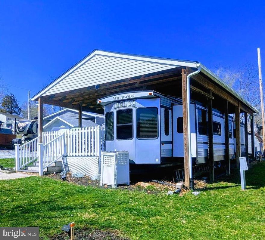 This stunning lot is ready for you to bring your personal belongings and start the 2025 river life. Lot comes with a pavilion, 2016 Forest River Wildwood DLX lodge model camper. This camper can sleep 8 people, two sofa beds, plus main bedroom in the camper as well as a bonus room with your own private entrance. Composite decking with non maintenance deck rails.   Deck has 3 ceiling fans. All outdoor and indoor furniture will convey.  This is a gated community so you need to enter at the guard shack. Entry is not permitted without ID per the office rules. Bring ID's to the office or guard shack for visitor pass. THIS IS A SEASONAL CAMPGROUND! OPEN FROM APRIL 1 TO NOVEMBER 1. ** WELCOME TO RIVER BEND/SEASONAL LOT AVAILABLE TURN KEY** River Bend is a privately owned 400 acre recreational- vehicle camp resort with seasonal activities for members, families and guests. This great RV park is tucked away on the Upper Potomac River of West Virginia, River Bend is one of West Virginia's most popular family seasonal destinations. . Just a short drive from the Washington and Baltimore metro area. Open with utilities from April 1 to November 1. Lot owners have access to their property the entire year. *** Members Enjoy *** * Amazing views and wildlife, Potomac River access, Trails, Swimming pools, Mini-Golf, Youth center, Tennis and basketball courts, laundry facilities, convenience store, deli and lounge. *Bath houses through out the park, boat ramp, bar and grill and even a church located on the grounds. River Bend also hosts numerous activities such as 4th of July fire works, small carnival, bonfires, poker runs, horse shoe tournaments, car show, Halloween Trick or Treat and so much more.