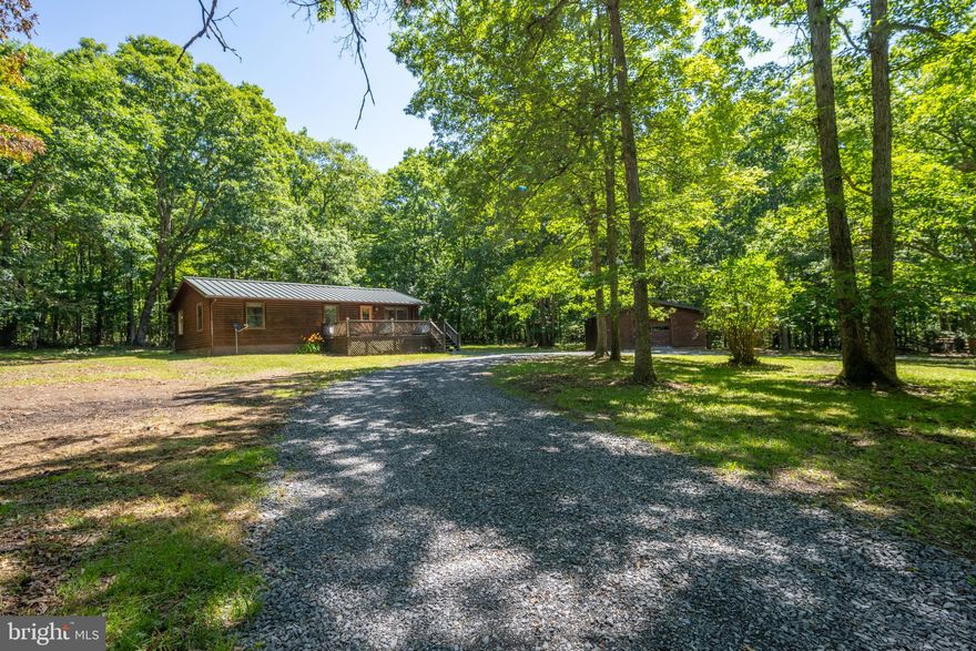 Cabin at the lake! Located along a gorgeous private lane, at the south end of Deep Creek, off of Greenglade Rd.  Adorable log sided cabin on a level & partially wooded lot, with towering trees.  It's the perfect simple setting offering privacy and one level living.