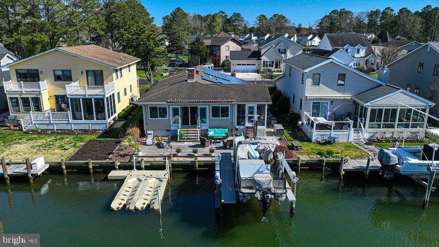 Fantastic one story waterfront home, on a very wide lagoon in the desired Teal Bay community of Ocean Pines! Wonderful views out to the St Martin River! This is perfect waterfront living!  New boatlift in 2020 and new 12 foot Anderson French gliding doors that lead out to a new waterfront deck, both installed in 2022.  The open floor plan of this home boasts a huge light filled great room with  rows of windows with amazing views! You will love the hardwood flooring, the remodeled kitchen, the gas fireplace, and the fabulous entertaining space!  The lovely waterfront deck and the large three season room (with extra refrigerator) expand the living space.  There is excellent storage at this home, including a large enclosed car port  with large locked closet; a shed closet in three season room; and a pull down attic with flooring. Nice size bedrooms, updated bathrooms and large laundry room.  This is Ocean Pines living at its best -- hop on your boat for a one minute ride out to the river and then motor on to the Yacht Club, the back bays, Assateague Island or one of the many wonderful waterfront restaurants in the area.