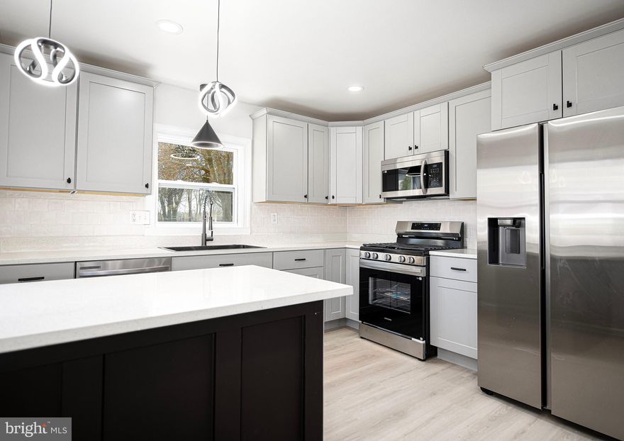 Welcome Home to the fully remodeled rancher including over 1800 sq ft of finished living space! This home features 3 bedrooms 2 full baths & 1-1/2 bath, true one level living and finished lower level. Enter the home to find an open concept floor plan including a bright & spacious living room with large bay window, new luxury vinyl flooring, new ceiling fan, and coat closet that flows into the dining area with new lighting and new luxury vinyl flooring. The well appointed fully updated kitchen includes brand new cabinetry, new quartz countertops, breakfast bar, pendant & recess lighting, new stainless steel appliances, new pantry cabinet, new ss farmhouse sink overlooking the backyard, luxury vinyl flooring, and side door leading to the driveway. Off the kitchen is a large mud/laundry room with brand new washer & dryer. The large primary suite has new carpet, new ceiling,  2 standard closets and a 5 x7 walk-in closet, fully updated primary on-suite bath, and new french doors leading to the rear patio. The primary on-suite bath has been fully updated with new ceramic tile flooring, new double sink vanity, new walk-in shower with ceramic tile surround & niche, new lighting & fixtures. Down the hall you will 2 more bedrooms both with new carpet, lighting, fresh paint and new doors as well as a fully updated hall bath with new ceramic tile flooring, tub/shower with ceramic tile surround & niche, new lighting & fixtures. The finished lower level family room has been updated with new carpet, recess lighting, fresh paint, and updated half bath. Step outside to the spacious, flat, fully fenced in rear yard with large concrete covered patio, and shed. Updates Include: New Roof, New Hot Water Heater, New Windows, New Garage Disposal, All New Doors, All New Flooring, Fully Remodeled Kitchen and Bathrooms, Fresh Paint, All New Lighting & So Much More!