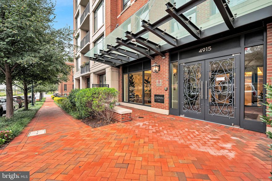 Light-filled, impeccably maintained, and ideally located in Hampden Row—one of Bethesda’s premier boutique luxury buildings. This spacious two-bedroom, two-and-a-half-bath residence offers approximately 1,600 square feet of thoughtfully designed living space, including a separate den/home office and a smart split-bedroom layout that maximizes both privacy and function.

Situated in the heart of Downtown Bethesda, the home is just steps from the area’s best shopping, dining, and entertainment options, with everything from fine restaurants to boutique fitness and cultural venues right at your doorstep.

Inside, the open-concept living and dining area is bright and welcoming, anchored by a modern kitchen with stainless steel appliances, a large island with seating, and custom high-quality built-ins offering ample storage—perfect for both everyday living and entertaining. Just off the living room, a private balcony provides a cozy outdoor escape—ideal for morning coffee or evening wine.

Each bedroom is positioned on opposite sides of the main living space and includes its own en-suite bath. The primary suite features dual vanities, a soaking tub, separate shower, and generous custom closet space. The second bedroom is equally spacious and well-appointed, while a powder room conveniently serves guests.

Additional highlights include two premium oversized garage parking spaces—side-by-side—with an EV charger already installed. Building amenities are exceptional: a stunning rooftop terrace with sweeping views, a large, fully equipped fitness center, an inviting club room, a beautifully appointed lobby, and 24-hour concierge service.

This is a rare opportunity to own a turnkey, designer residence in one of Bethesda’s most coveted buildings—offering the perfect blend of luxury, space, and convenience. Truly exceptional—and not to be missed.