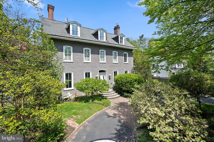 Indulge in the epitome of Main Line living at 419 Conestoga Road, nestled in Radnor Township's coveted Wayne neighborhood. Enter a Belgian block-lined semi-circular driveway, with ample parking, where you are greeted with a tall arbor on a stone wall, a fountain and a circular flower bed to meet this distinguished stone-built residence, which seamlessly merges historic charm with modern luxury, offering a lifestyle of elegance and sophistication. 
Step through the custom-built wood front entryway into a world of grandeur, where 10-foot ceilings and original architectural details mingle effortlessly with modern updates. From the inviting front hall with its antique brass insert and wood inlaid mirror to the formal dining and living rooms adorned with ornate fireplaces and tall arched French windows, each space tells a story of impeccable craftsmanship and attention to detail.
The heart of the home lies in the expansive eat-in kitchen, where a large fireplace, custom cabinetry, and gourmet chef's amenities create the perfect setting for gathering and entertaining. This level also includes a walk-in mudroom with a cathedral ceiling, an expansive porch, a walk-in pantry, and a convenient half bath.
Retreat to the luxurious en-suite primary bedroom and bath, recently renovated to offer ultimate comfort and relaxation. Pamper yourself in the spa-like bathroom complete with a Jacuzzi tub, rainforest curb-less shower, and Japanese Toto toilet with bidet. Heated floors and a built-in sound system add to the ambiance of serenity. Three additional bedrooms and a full bath round out the second floor, along with a rear staircase leading to the kitchen.
Venture up to the third floor to discover four additional rooms that can be utilized as bedrooms, offices, or exercise room plus another full bath, offering versatility for various lifestyle needs. The partially finished basement provides over 2,000 square feet of space, including a laundry room, workshop, game room, and potential wine cellar.
Host al fresco dinners on the spacious rear porch, overlooking the professionally landscaped grounds with its gas fireplace and fire pit—an oasis of tranquility and natural beauty.   A perfect spot for hosting large parties and gatherings. A 10-zone sprinkler system helps maintain a healthy and beautiful yard. Two storage sheds accommodate outdoor essentials, while the expansive back porch and stone terrace with fireplace and seating offer an ideal setting for outdoor entertaining. The built-in sound system and four-zone low-voltage lighting system enhance the backdrop for gatherings.
Beyond its elegance and charm, this home offers practical modern amenities such as a new dual-zone HVAC system, remote-controlled gas fireplaces, and heated floors throughout the working kitchen and master bath. With a fully fenced private gated backyard, walking distance to the Radnor Trail, and proximity to top-rated schools, parks, and shopping centers, it's the perfect blend of luxury and convenience for discerning buyers.
Notably, this property enjoys low real estate taxes relative to its value in Radnor, offering additional appeal to prospective buyers. Don't miss your chance to own a piece of history in one of Pennsylvania's most desirable neighborhoods. Welcome home to 419 Conestoga Road—where elegance, charm, and modern comfort await.