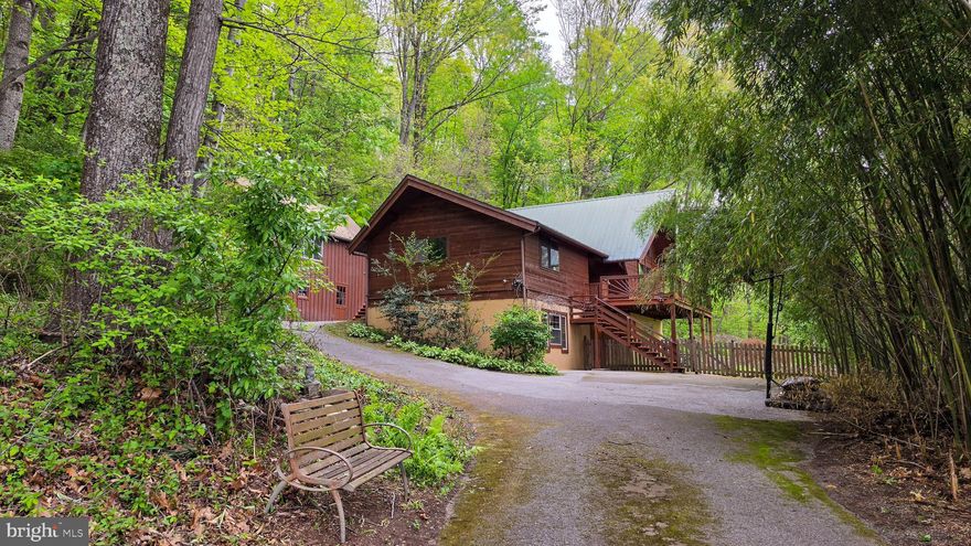 Enjoy the sounds  of birds and immerse yourself in nature as you walk through the gardens and trails or sit on the front deck overlooking the rolling hills of Southern York County PA. This beautiful home offers peace and tranquility in the middle of 4 wooded acres. Vaulted ceilings and large windows as well as a wood burning fireplace are the centerpiece of the home in the great room. The kitchen has upgraded appliances and a large pantry. The primary suite is on the main level of the home and has large closets and vaulted ceilings. The second level is a loft that could be used as a great office, music room,  or converted to a bedroom.  The walkout basement is finished offering one bedroom, a family room with pellet stove, a full bath, and a finished utility room. 

Outside, in addition to the great deck, you will find an additional deck, a stone paver patio, a fountain, and a rock climbing wall. There is also a single car detached garage that has a finished space above it that includes a single room, closets, and a full bath.
