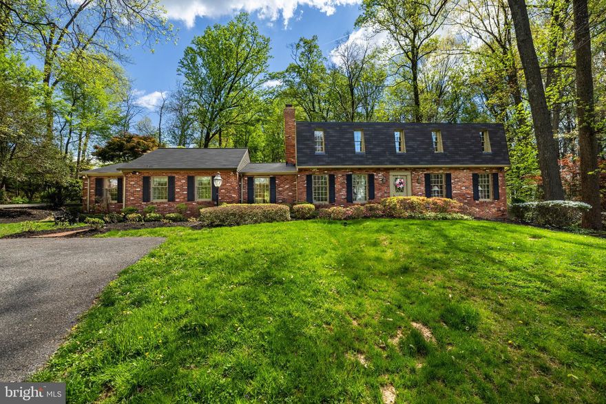 This well constructed Dutch Colonial is elegantly situated on an elevated lot in Summer Hill, a desirable Phoenix location. The house has been expanded to include a primary bedroom suite on the main floor with a luxury bathroom, its own laundry, and a spacious walk-in closet with custom built-ins. The second floor includes four additional bedrooms, one with  an en-suite bathroom, a hall bathroom and a second laundry. 
The kitchen opens to an expansive  family room with 2 sets of French doors opening to the surrounding decks. Natural light fills the room which also has vaulted ceilings, and a fireplace. The home features hardwood floors throughout. The finished lower level includes a bar and built-ins, a full bathroom and ample storage.  A detached, oversized brick two-car garage offers additional storage. For summer entertaining, two outdoor living spaces open onto a lovely, flat, manicured yard. The original stone spring house, part of the initial estate property sits ideally on the front yard and is constantly admired by neighbors and passersby and adds to the charm of this exceptional property.