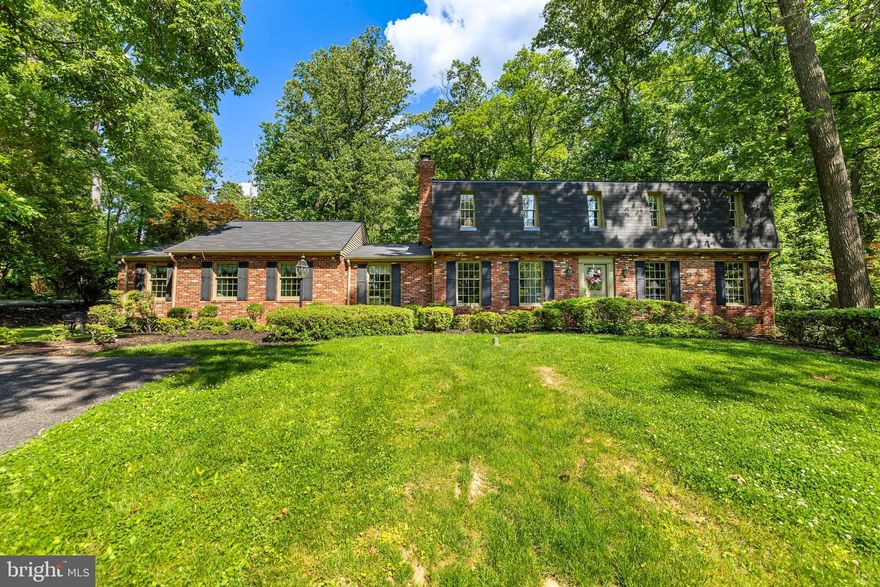 This well constructed Dutch Colonial is elegantly situated on an elevated lot in Summer Hill, a desirable Phoenix location. The house has been expanded to include a primary bedroom suite on the main floor with a luxury bathroom, its own laundry, and a spacious walk-in closet with custom built-ins. The second floor includes four additional bedrooms, one with  an en-suite bathroom, a hall bathroom and a second laundry. 
The kitchen opens to an expansive  family room with 2 sets of French doors opening to the surrounding decks. Natural light fills the room which also has vaulted ceilings, and a fireplace. The home features hardwood floors throughout. The finished lower level includes a bar and built-ins, a full bathroom and ample storage.  A detached, oversized brick two-car garage offers additional storage. For summer entertaining, two outdoor living spaces open onto a lovely, flat, manicured yard. The original stone spring house, part of the initial estate property sits ideally on the front yard and is constantly admired by neighbors and passersby and adds to the charm of this exceptional property.