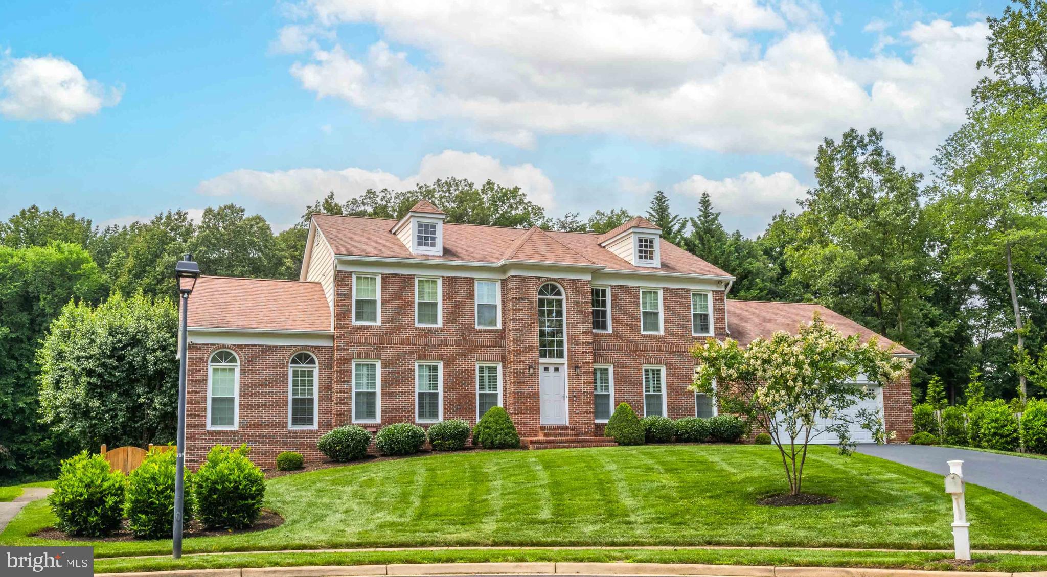 Nestled in the prestigious Summerfield community, this exquisite Colonial-style residence, thoughtfully renovated in 2005, offers a Main Level and Upper Level Primary Bedrooms. With its elegant brick front, the home exudes curb appeal, inviting you to explore the high-end features within. Step inside to discover a spacious and open floor plan that seamlessly connects the living spaces, perfect for both entertaining and everyday living. The office addition off the living room, features cathedral ceiling, hardwood floors and 3 walls of windows. The gourmet kitchen is a chef's dream, boasting stainless steel appliances, a double oven, and a convenient island that encourages culinary creativity. The butler's pantry adds an extra touch of sophistication, while the built in island seating provides a cozy spot for morning coffee. The main level features a two story family room off the kitchen, complete with a gas fireplace, creating a warm ambiance for gatherings. A formal dining room and a separate living area offer additional spaces for entertaining. Retreat to the main level primary suite, where you'll find a spa-like bathroom featuring a soaking tub and a walk-in shower, complemented by elegant finishes. On the upper level you will find a second primary suite with his & her dressing areas and closets. There is also an additional bedroom with an ensuite bath on this level. The lower level is a true gem, featuring a daylight walkout design that leads to the beautifully fenced backyard. During the cold months of winter, the steam shower located in the bath on this level or the sauna in the room next it will keep you warm. The oversized 4th bedroom is found here, complete with windows that invite natural light. The expansive Rec Room is perfect for entertaining with a bar and a fireplace. Two separate storage areas are also located on this level. Outside, the property sits on a premium 0.33-acre lot, is backing onto a serene open common area. Enjoy the tranquility of the cul-de-sac location, enhanced by professional landscaping. The expansive deck and terrace provide an ideal setting for al fresco dining or simply unwinding in the hot tub. Additional highlights include energy-efficient Pella double-pane windows, 2 Zone HVAC replaced 2023, ventless gas fireplace, hardwood floors, and a main floor laundry for added convenience. The oversized attached heated garage (with remote for the heater) accommodates two vehicles, with ample driveway space for guests. This home is not just a residence; it's a lifestyle with kitchen and basement switches controlled by Alexa. Experience the perfect blend of luxury, comfort, and community in this exceptional property, where every detail has been meticulously crafted for your enjoyment.