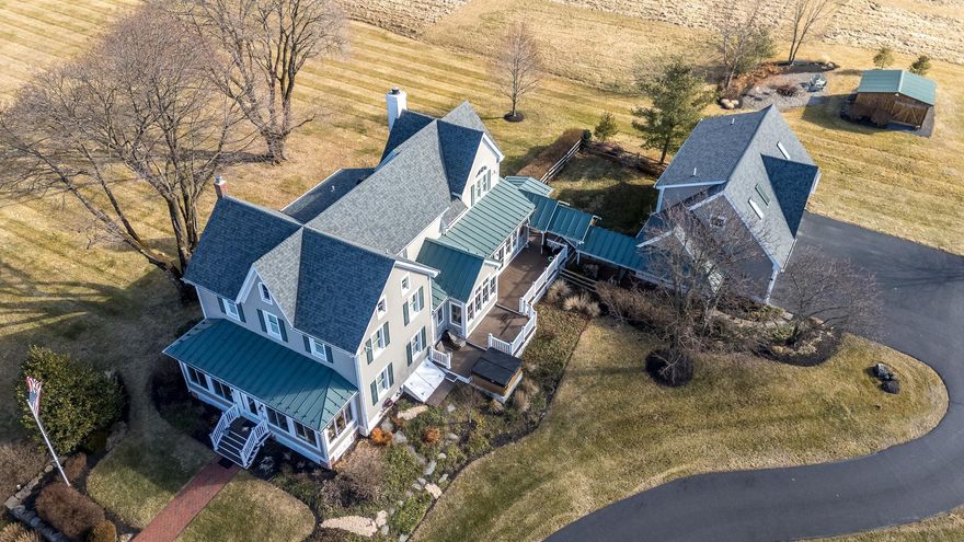 Embrace the Allure of This Home in a Prime Location — 40 Foellner Lane, Ottsville, PA. Discover a rare private sanctuary in Nockamixon Township, set on 10.89 breathtaking acres with your very own scenic pond and iconic windmill. This beautifully transformed 1890 farmhouse has been expertly reimagined by renowned Bucks County architect and builder George J. Donovan. Tucked away on one of Upper Bucks County's most secluded roads, it offers tranquil views of open farmland and Haycock Mountain—the highest peak in Bucks County at 974 feet, also known as Ghost Mountain.
This cheerful home is filled with natural light, thanks to an abundance of energy-efficient windows that provide peaceful views from nearly every room. Beautiful hardwood floors grace the interiors, enhancing the inviting atmosphere.
Enter through the delightful enclosed porch, adorned with rich mahogany floors and tall insulated windows — a serene sitting area perfect for relaxation, reading, or enjoying spectacular sunsets over Haycock Mountain and the nearby farm. This welcoming entrance gracefully leads into the formal living and dining rooms, showcasing elegant coffered ceilings that enhance the home's sense of space and grandeur.
At the heart of the home lies a truly exceptional chef’s kitchen, featuring:
• State-of-the-art appliances, including a Wolf range with six gas burners, a flat griddle cooktop, and dual ovens
• A built-in Wolf microwave convection oven
• A commercial Sub-Zero refrigerator/freezer with a stainless steel interior
• Two-drawer Fisher & Paykel dishwashers
• A massive quartz island, multiple sinks, a separate wet bar/coffee bar, and a spacious walk-in pantry
The bright eat-in area, with its bump-out overlooking the expansive lawn and scenic pond, seamlessly flows into the warm and inviting family room, which boasts a wood-burning fireplace and a large wall of windows revealing stunning views of the back property.
Upstairs, discover a luxurious primary suite — an elegant owner’s retreat featuring:
• Two spacious walk-in closets
• A beautifully updated en-suite bathroom with washer/dryer
Three additional bedrooms complete the upper level, one with its own private bathroom. The lower level of the main house also includes a functional office area. An expansive walk-up attic on the third floor, featuring cedar walls, offers abundant storage and easy stair access.
Above the heated and air-conditioned three-car garage, a private guest or in-law suite awaits, connected by a breezeway with a tin roof — ideal for extended family, guests, or as a personal retreat.
The lower level also includes a clean, functional basement area that houses the whole-house water conditioning system with a UV filter, ensuring pristine water throughout the property.
Professionally landscaped grounds beautifully surround the home. A covered back porch serves as the perfect spot to enjoy the gentle breezes coming off the open land. Unwind on the Trex deck with a hot tub and soak in the tranquility of your private, park-like acreage. Just steps away is Nockamixon State Park and the expansive 1,450-acre Lake Nockamixon — a boater’s and angler’s paradise offering sailing, kayaking, canoeing, fishing, and more. The park also features miles of hiking and biking trails, along with a swimming pool.
Conveniently located near Ottsville, explore Linden Hill’s botanical gardens, the unique Ringing Rocks, and the Delaware River, all just minutes away. Peddler’s Village, the Bucks County Children’s Museum, Doylestown, and New Hope are all a short drive away for shopping, dining, and entertainment.
Impeccable finishes, thoughtful custom details, and unmatched privacy deliver the ultimate Bucks County lifestyle — a true escape into peace, natural beauty, and timeless elegance.