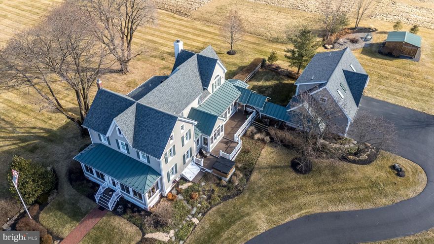 Discover the charm of this home in a prime location, now thoughtfully priced. 40 Foellner Lane, Ottsville PA

Rare private sanctuary in Nockamixon Township on 10.89 breathtaking acres, complete with your own scenic pond and iconic windmill. This stunningly transformed 1890 farmhouse was masterfully reimagined by acclaimed Bucks County architect/builder George J. Donovan. Nestled on one of the most private roads in Upper Bucks County, it offers serene views of open farmland and Haycock Mountain — Bucks County’s highest peak at 974 feet, also known as Ghost Mountain.

This light-filled, cheery, and bright home features beautiful hardwood floors throughout and is flooded with natural light from an abundance of energy-efficient windows that frame peaceful views from nearly every room.

At the heart of the home is the chef’s dream kitchen — truly exceptional, boasting state-of-the-art appliances including a Wolf range with 6 gas burners, flat griddle cooktop, and dual ovens, a built-in Wolf microwave convection oven, a commercial Sub-Zero refrigerator/freezer with stainless steel interior, two-drawer Fisher & Paykel dishwashers, a massive quartz island, multiple sinks, a separate wet bar/coffee bar, and a large walk-in pantry. The bright eat-in area sits in a bump-out overlooking the expansive lawn and scenic pond, flowing naturally into the warm and inviting family room on the main level. The family room features a wood-burning fireplace and a huge wall of windows that frame sweeping views of the back property.

You enter through the charming enclosed porch with rich mahogany floors and tall insulated windows — a serene sitting room perfect for relaxing, reading, or savoring spectacular sunsets over Haycock Mountain and the farm across the street. This welcoming entrance opens gracefully into the formal living and dining rooms, which impress with elegant coffered ceilings that enhance the home’s sense of space and grandeur.

Upstairs awaits a luxurious primary suite — an elegant owner’s retreat complete with two spacious walk-in closets and a beautifully updated en-suite bathroom with washer/dryer. Three additional bedrooms finish the upper level, one with its own private bathroom. The lower level of the main house offers a functional office area. A spacious walk-up attic on the third floor, with cedar walls, provides abundant storage and easy stair access.

A private guest/in-law suite is situated above the heated and air-conditioned three-car garage, connected by a breezeway with a tin roof — offering ideal space for extended family, guests, or a personal retreat.

The lower level of the main house also includes a clean, functional basement area that houses the whole-house water conditioning system with UV filter, ensuring pristine water throughout the entire property.

Outside, professional landscaping beautifully surrounds the home. A covered back porch is the perfect spot to enjoy gentle breezes off the open land. Relax on the Trex deck with hot tub and soak in the tranquility of your private, park-like acreage. Just steps away is Nockamixon State Park and the expansive 1,450-acre Lake Nockamixon — a boater’s and angler’s paradise offering sailing, kayaking, canoeing, fishing, and more. The park also provides miles of hiking and biking trails, plus a swimming pool.
Conveniently located near Ottsville, discover Linden Hill’s botanical gardens, the unique Ringing Rocks, and the Delaware River just minutes away. Peddler’s Village, the Bucks County Children’s Museum, Doylestown, and New Hope are all a short ride away for shopping, dining, and entertainment.

Impeccable finishes, thoughtful custom details, and unmatched privacy deliver the ultimate Bucks County lifestyle — a true escape into peace, natural beauty, and timeless elegance.